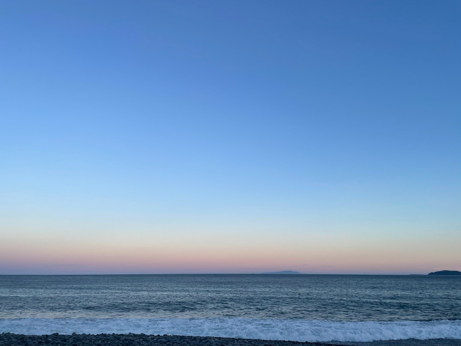 Ruhige Landschaft mit einem Farbverlauf am Himmel und ruhigem Meer