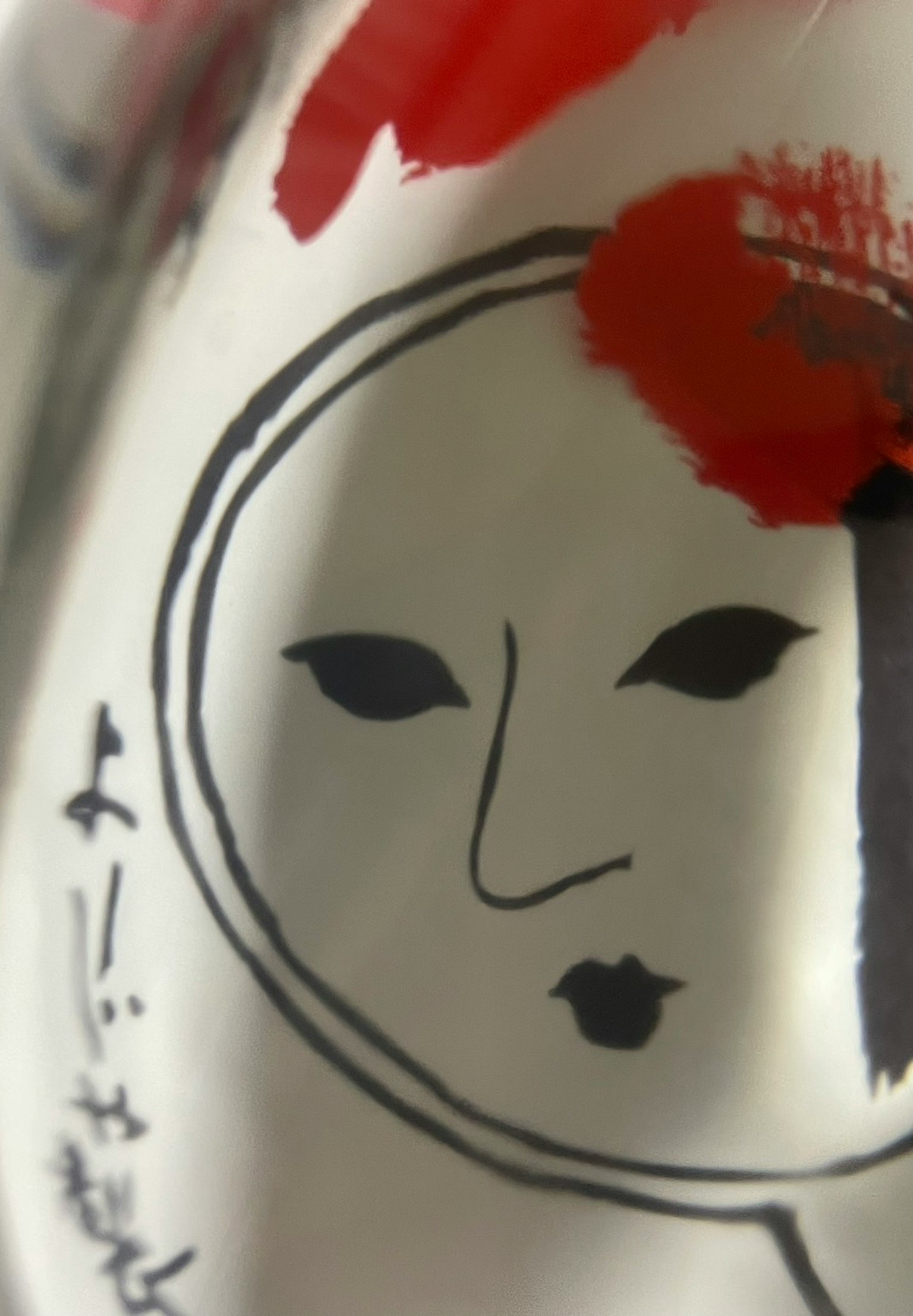 White ceramic with a black face design featuring red accents and text