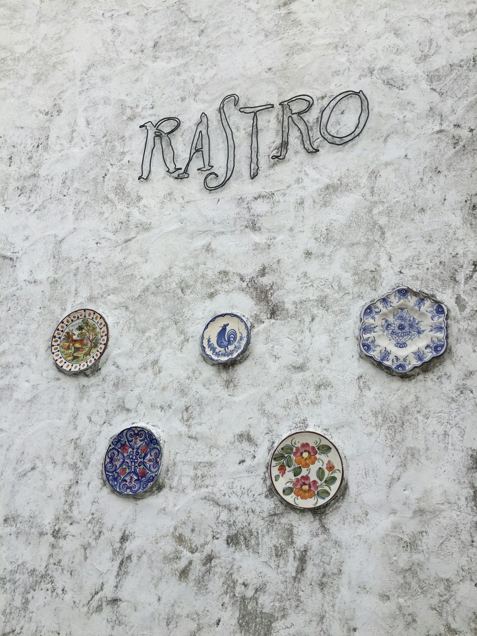 牆上掛著的彩色盤子和字母RASTRO