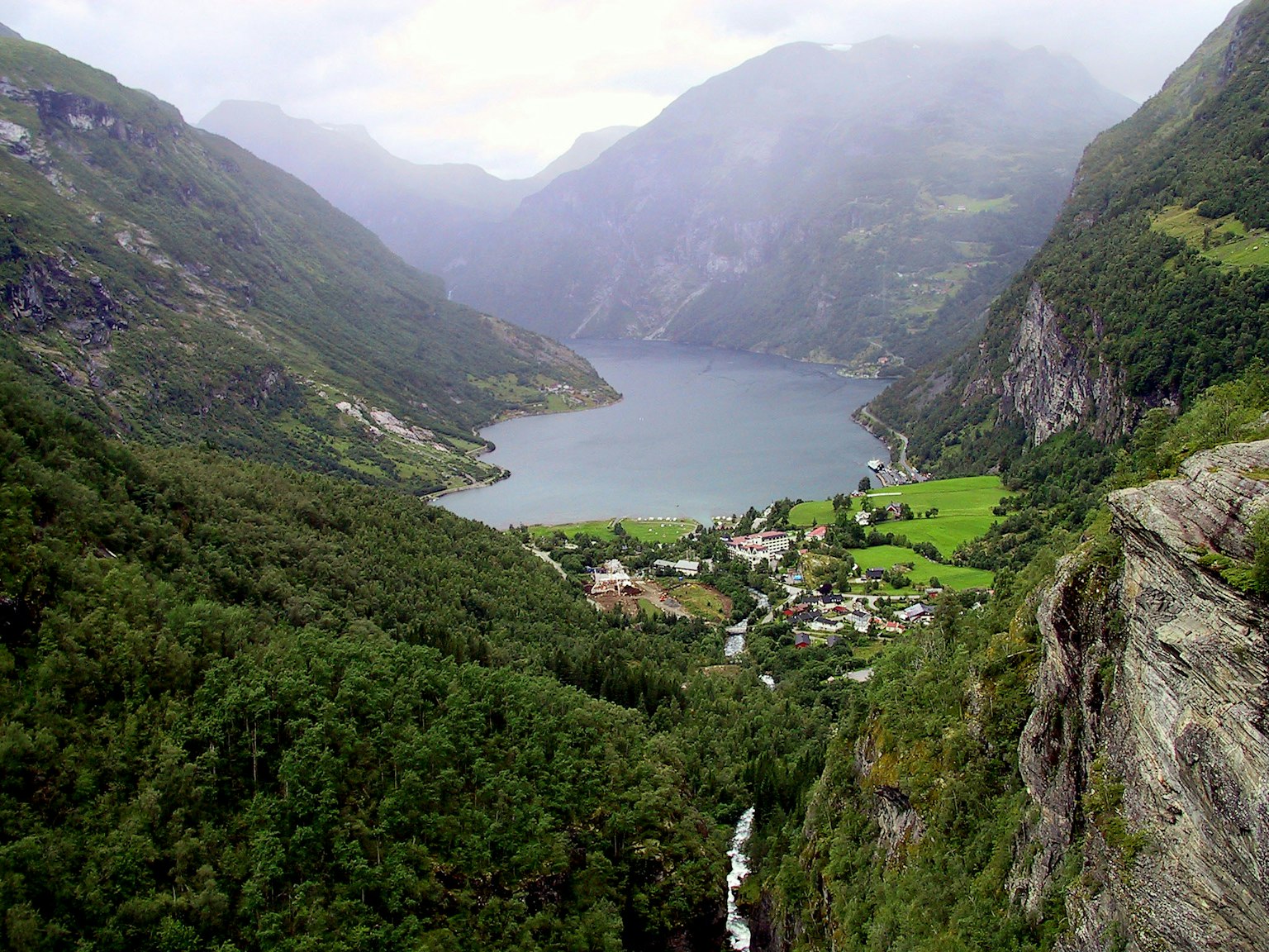Malersicher Fjordblick umgeben von Bergen üppigen grünen Hügeln und einem kleinen Dorf