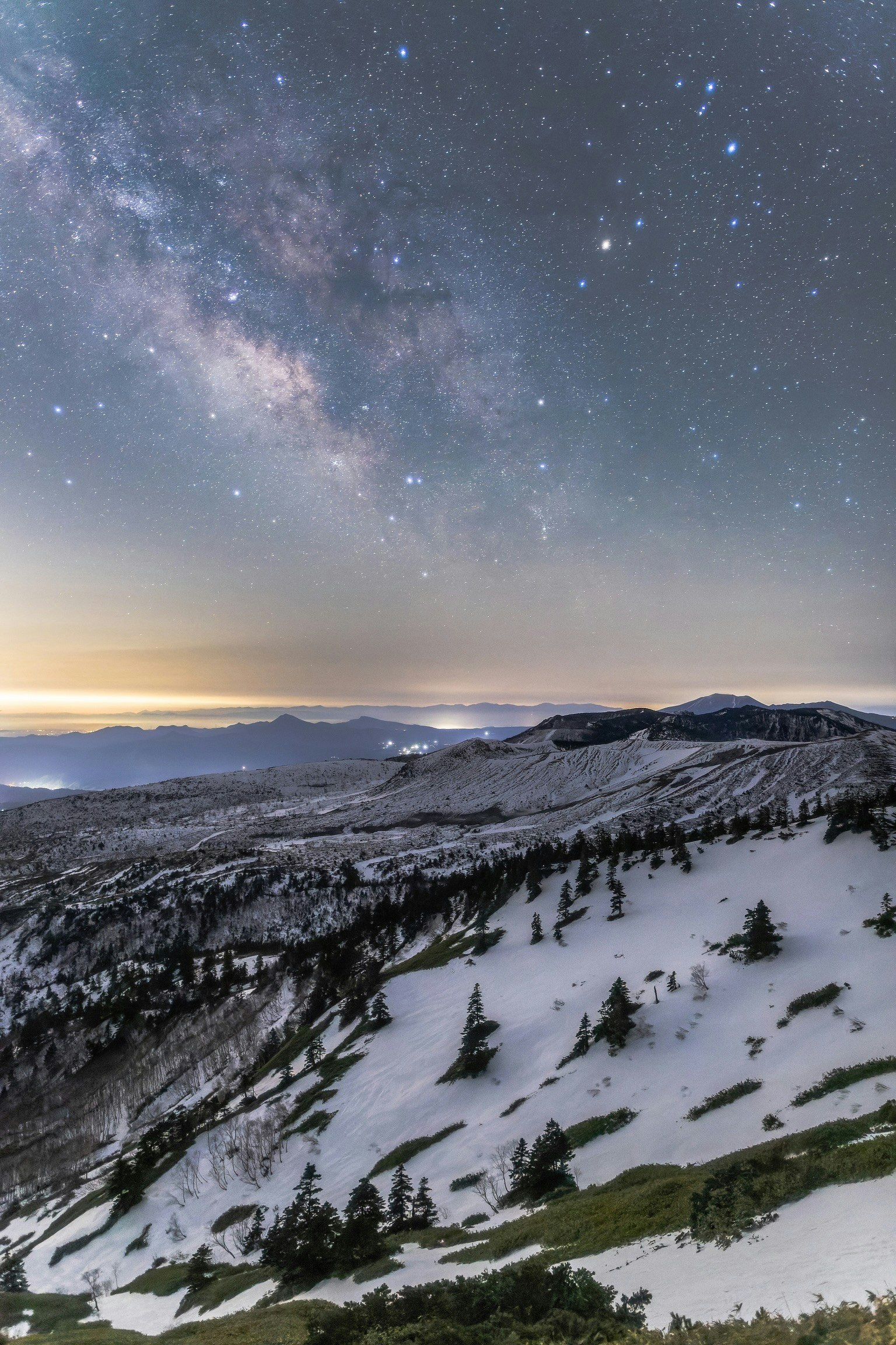 Montañas cubiertas de nieve bajo un hermoso cielo estrellado