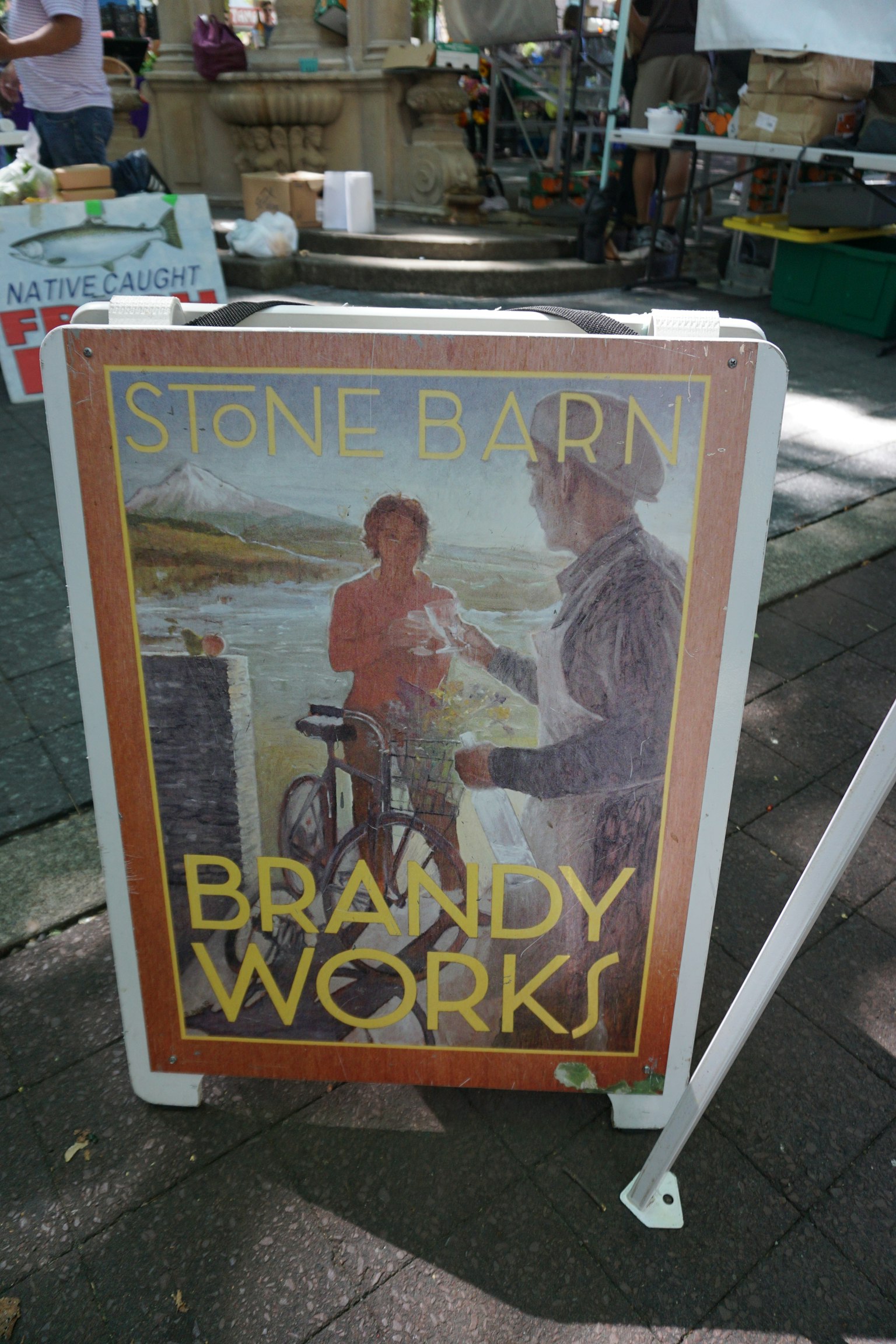 Stone Barn Brandy Works的招牌上有人物和自行車