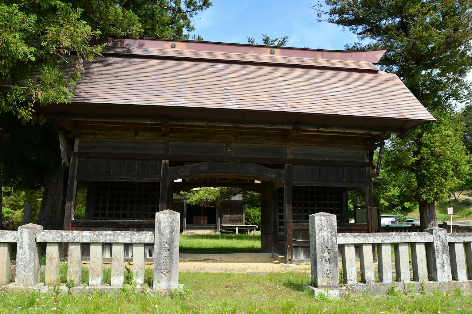 Porte en bois traditionnel avec clôture en pierre dans un paysage serein