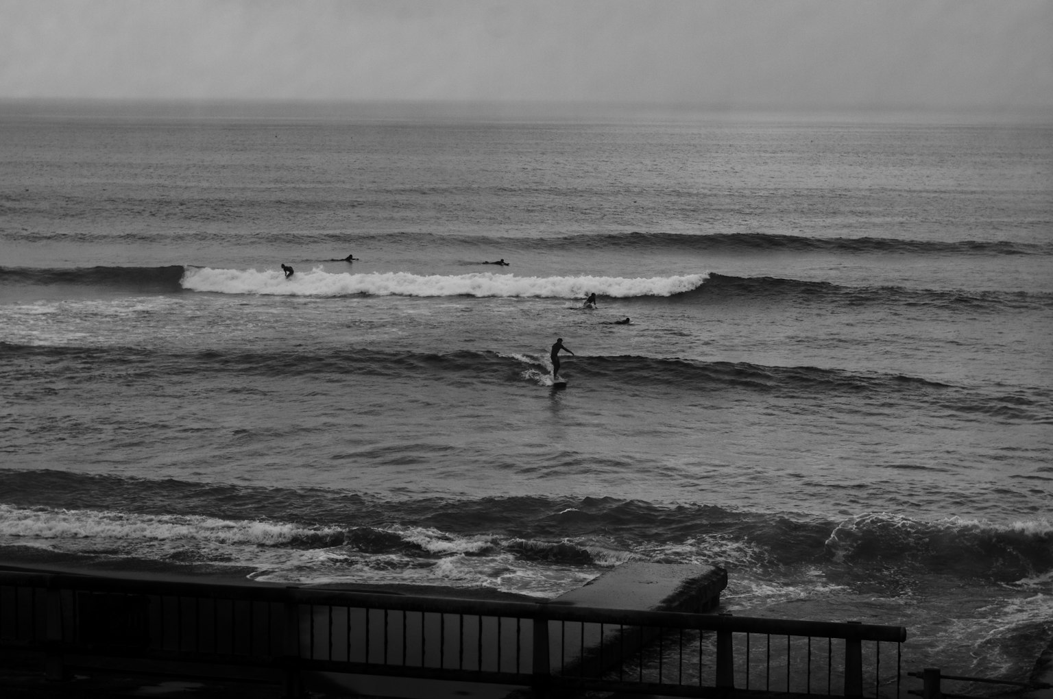 Black and white image of a person surfing in the ocean