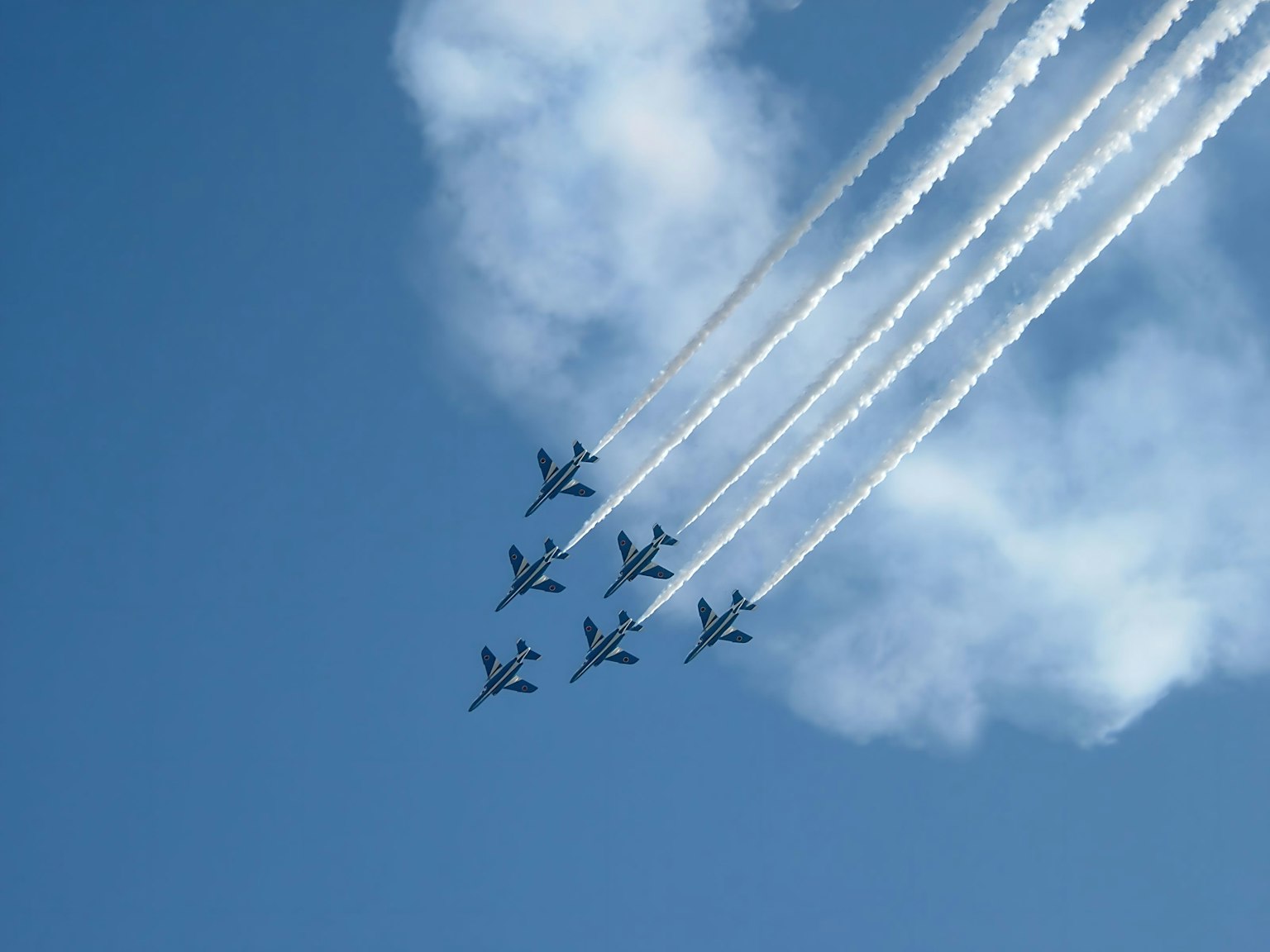 Formación de aviones volando en el cielo azul dejando estelas de humo blanco