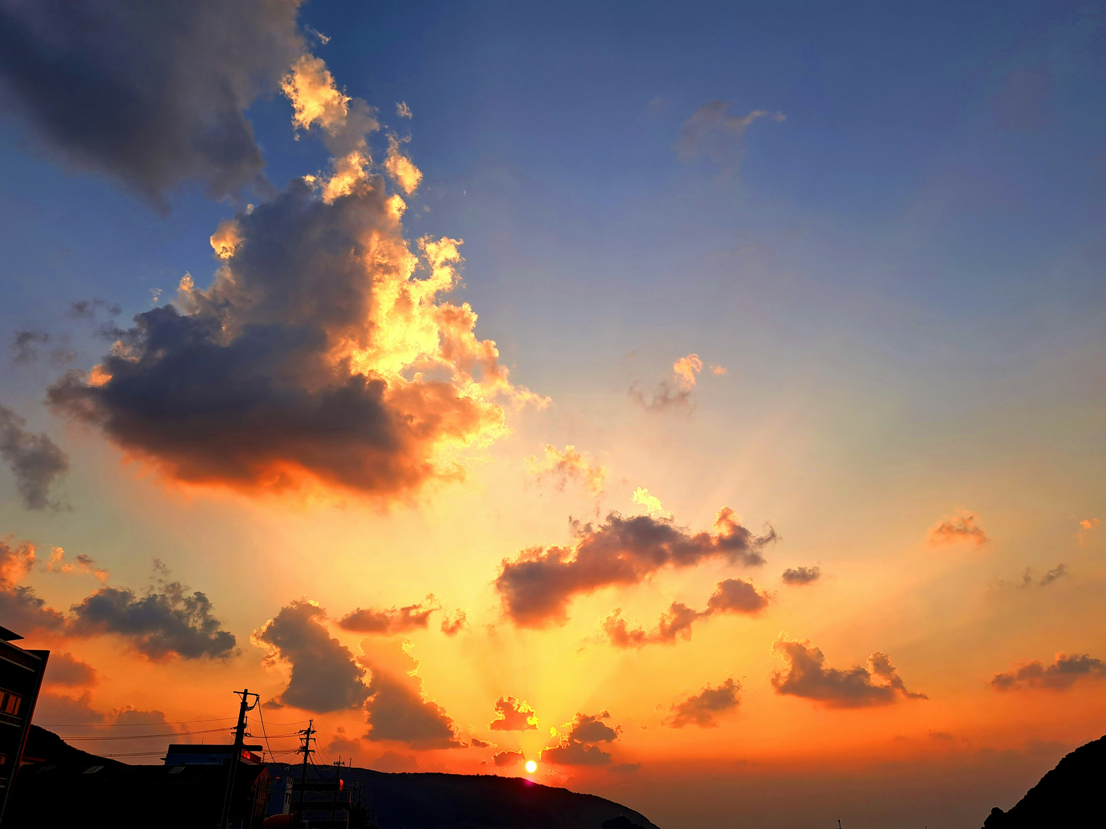 夕暮れの空に燃えるような雲と太陽