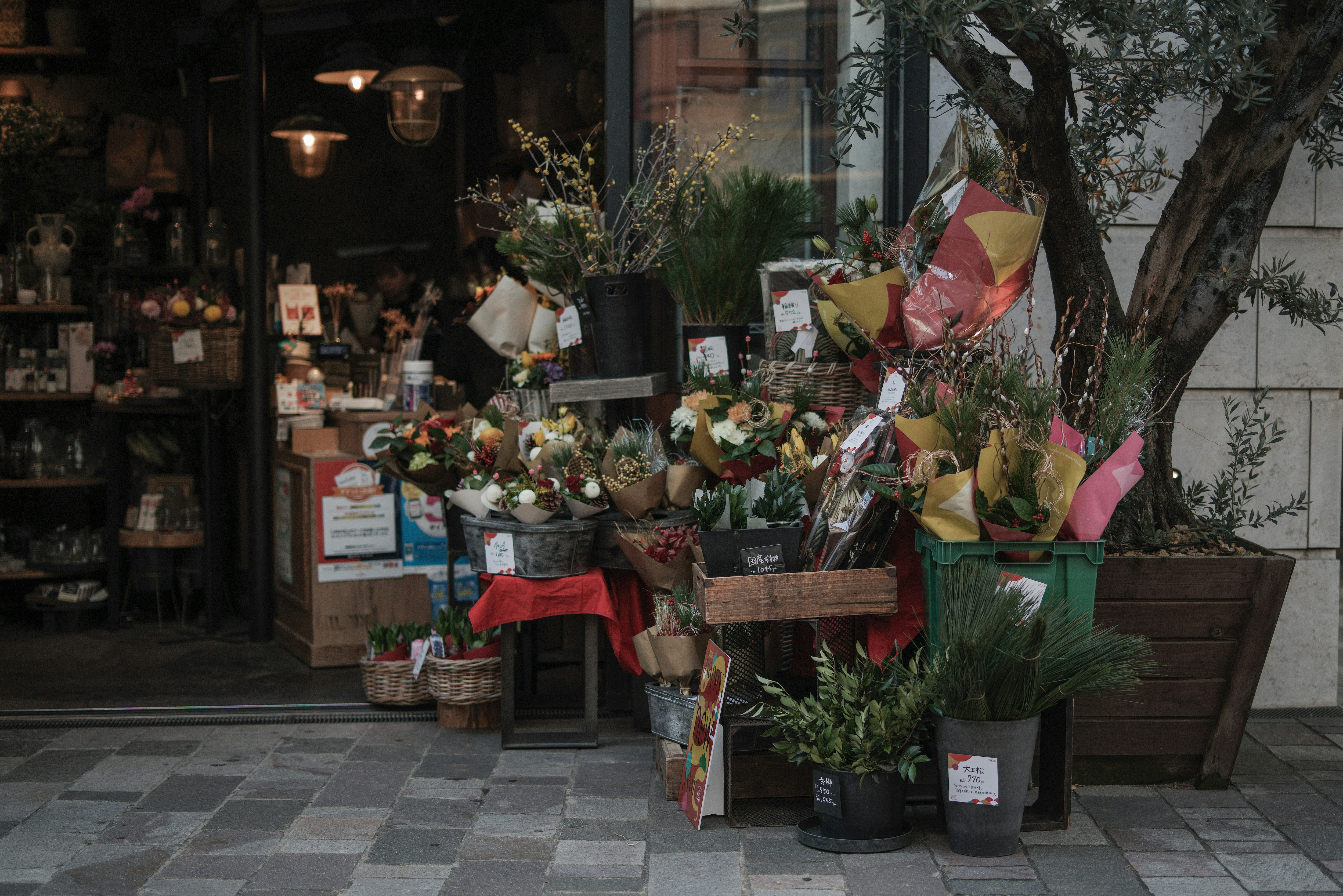 花束や鉢植えが並ぶ路地の花屋の軒先