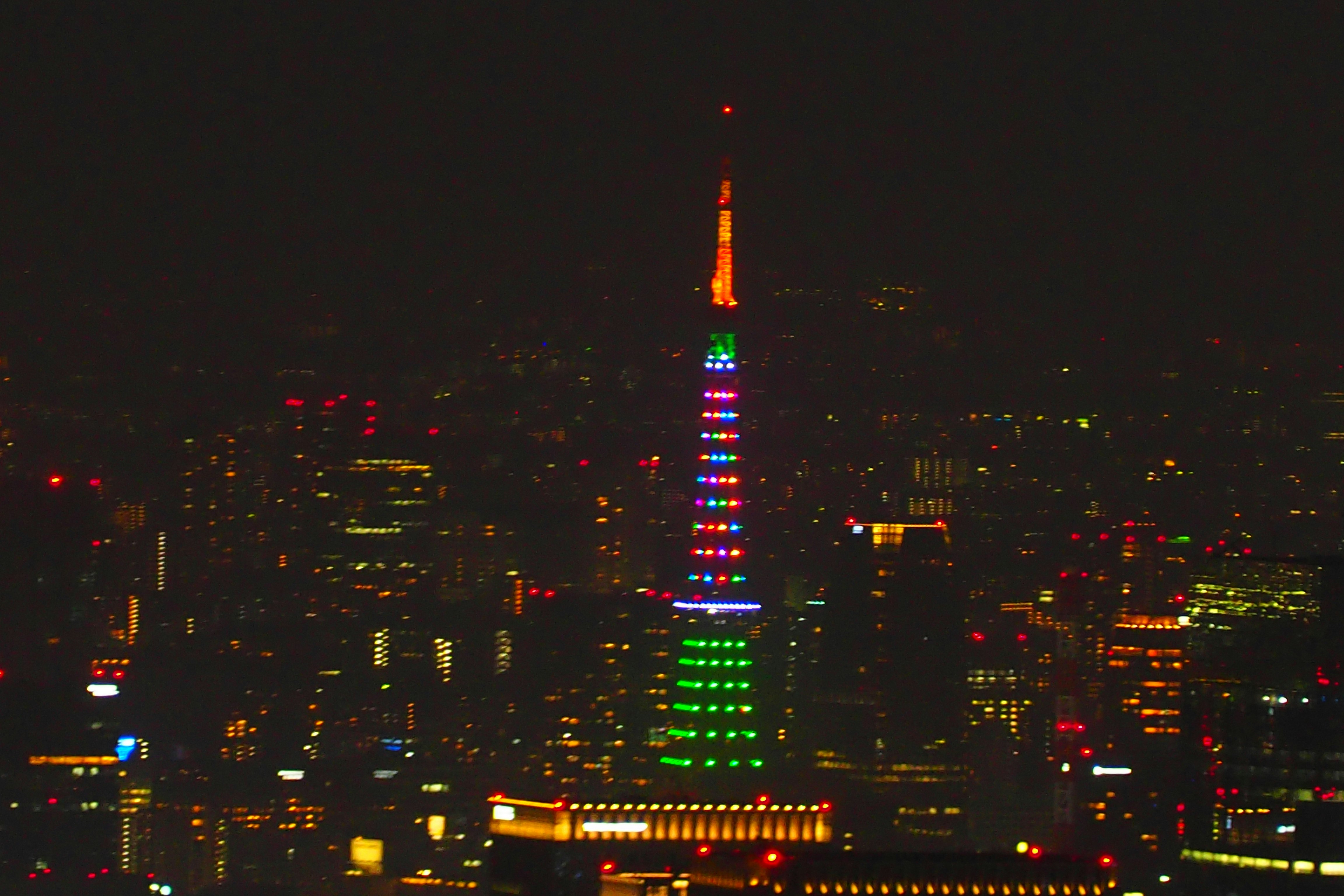skyline urbano notturno con una torre illuminata e grattacieli