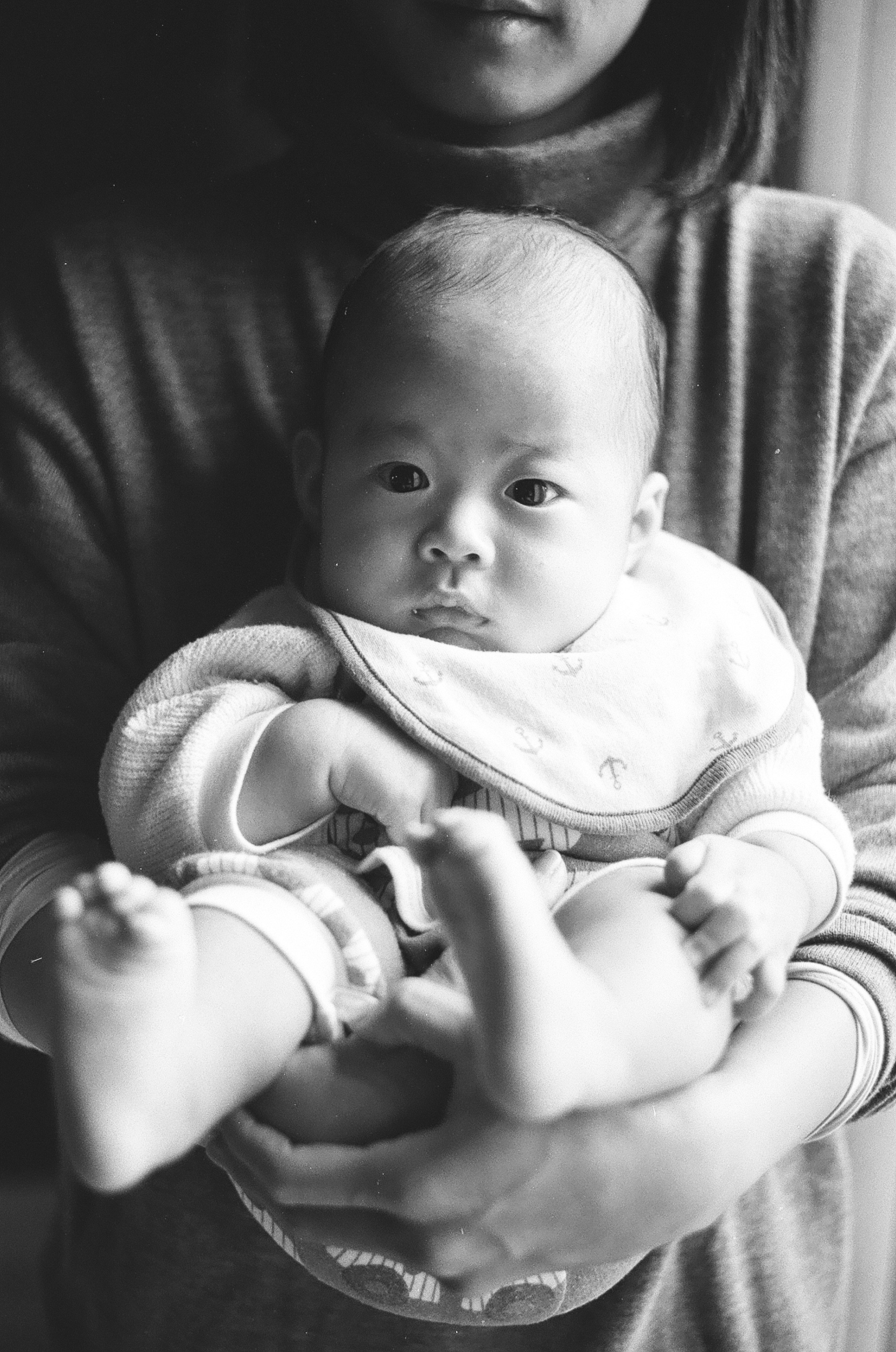 black-and-white parent holding a baby with a calm expression