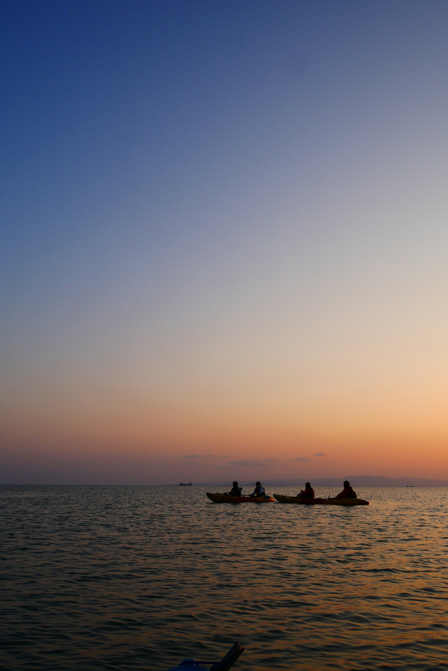Kayak su un mare calmo al tramonto con cielo sfumato