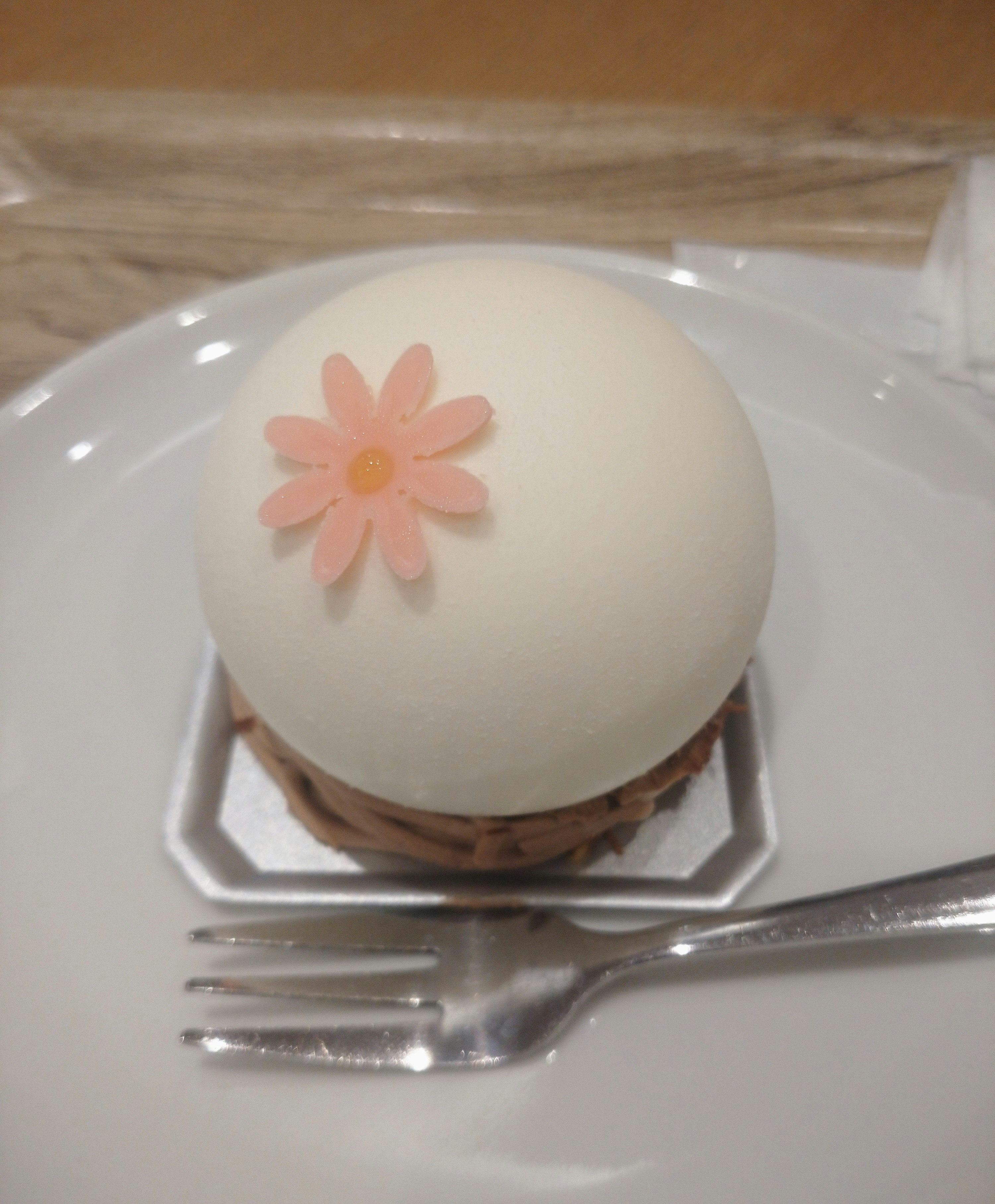 白い花のデコレーションが乗ったケーキ