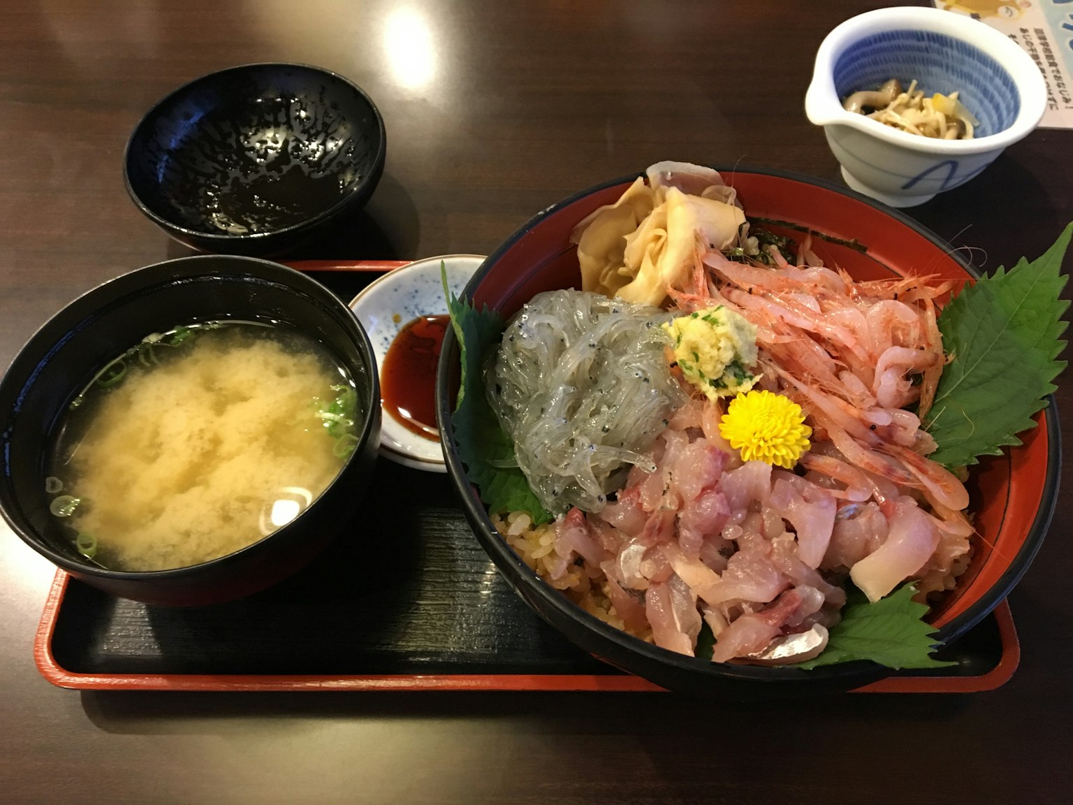 Eine bunte Sashimi-Schüssel serviert mit Miso-Suppe