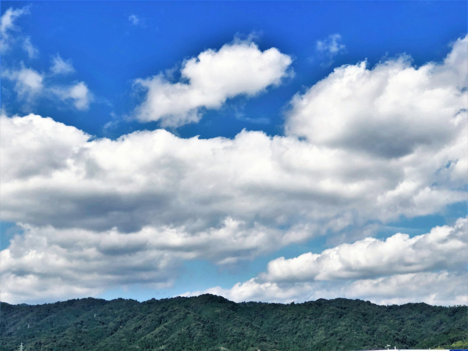 藍天白雲與綠色山丘的風景