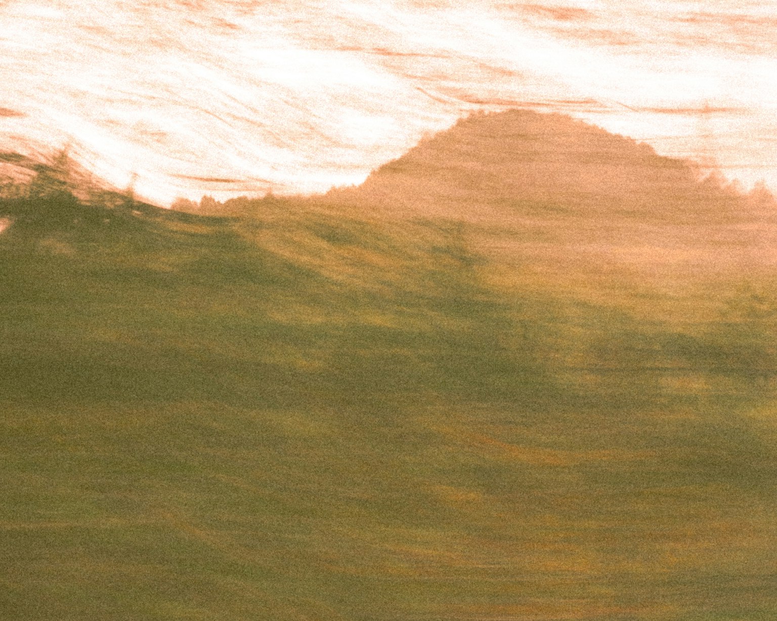 Abstract landscape image with soft color tones featuring green and orange gradients