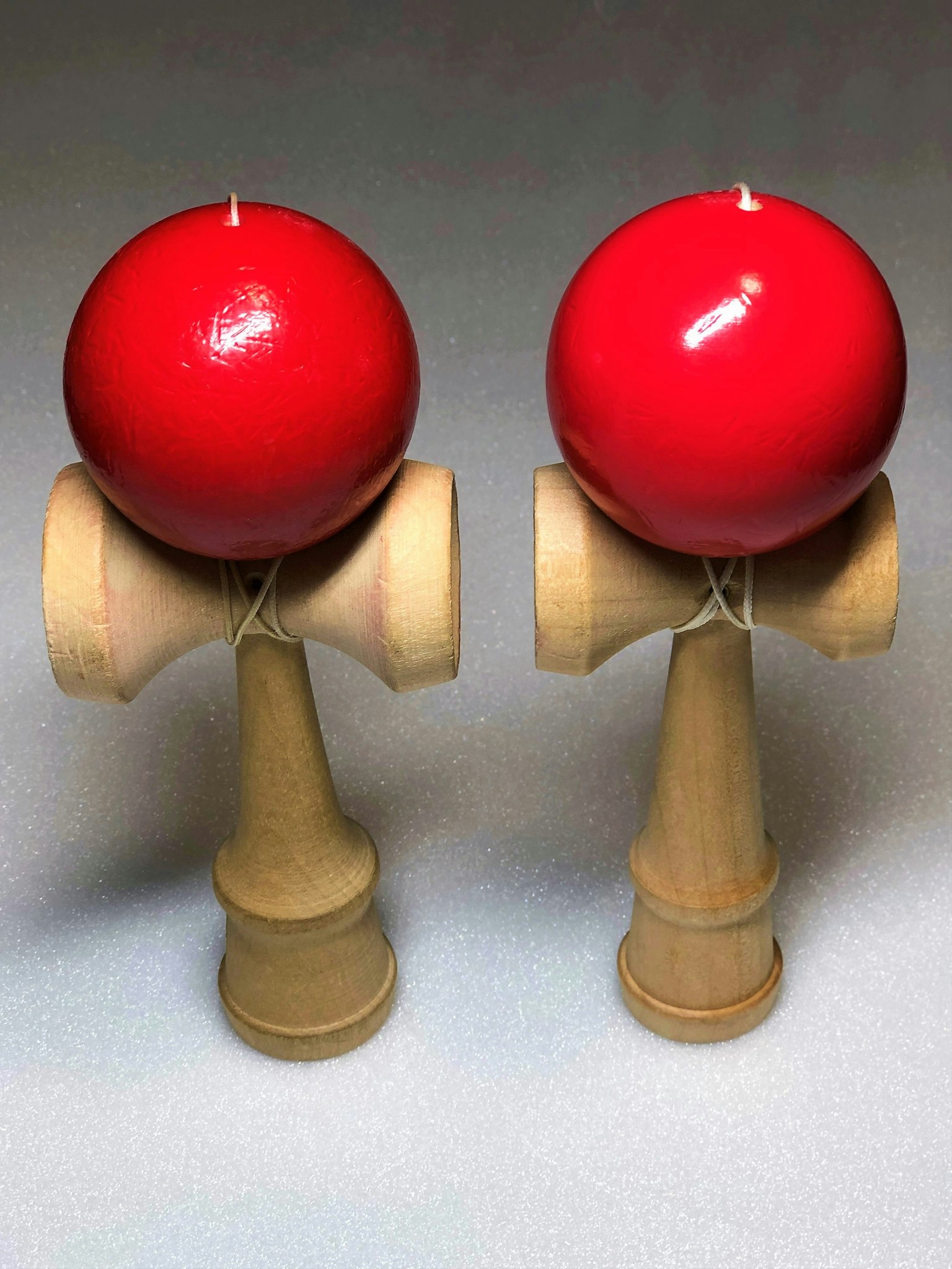 两个带红球的剑玉玩具并排展示