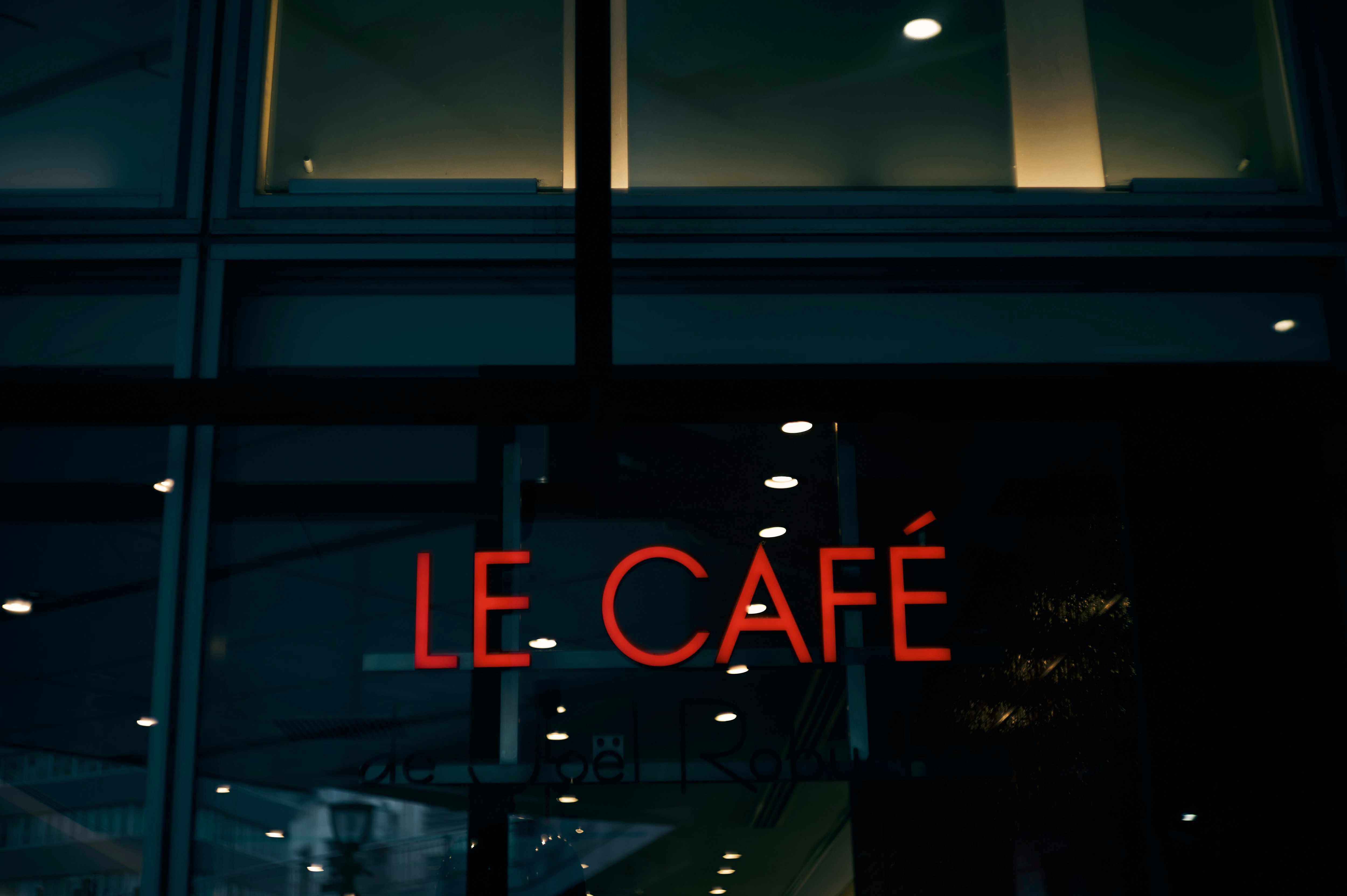 「LE CAFÉ」の看板が見える夜のカフェ外観