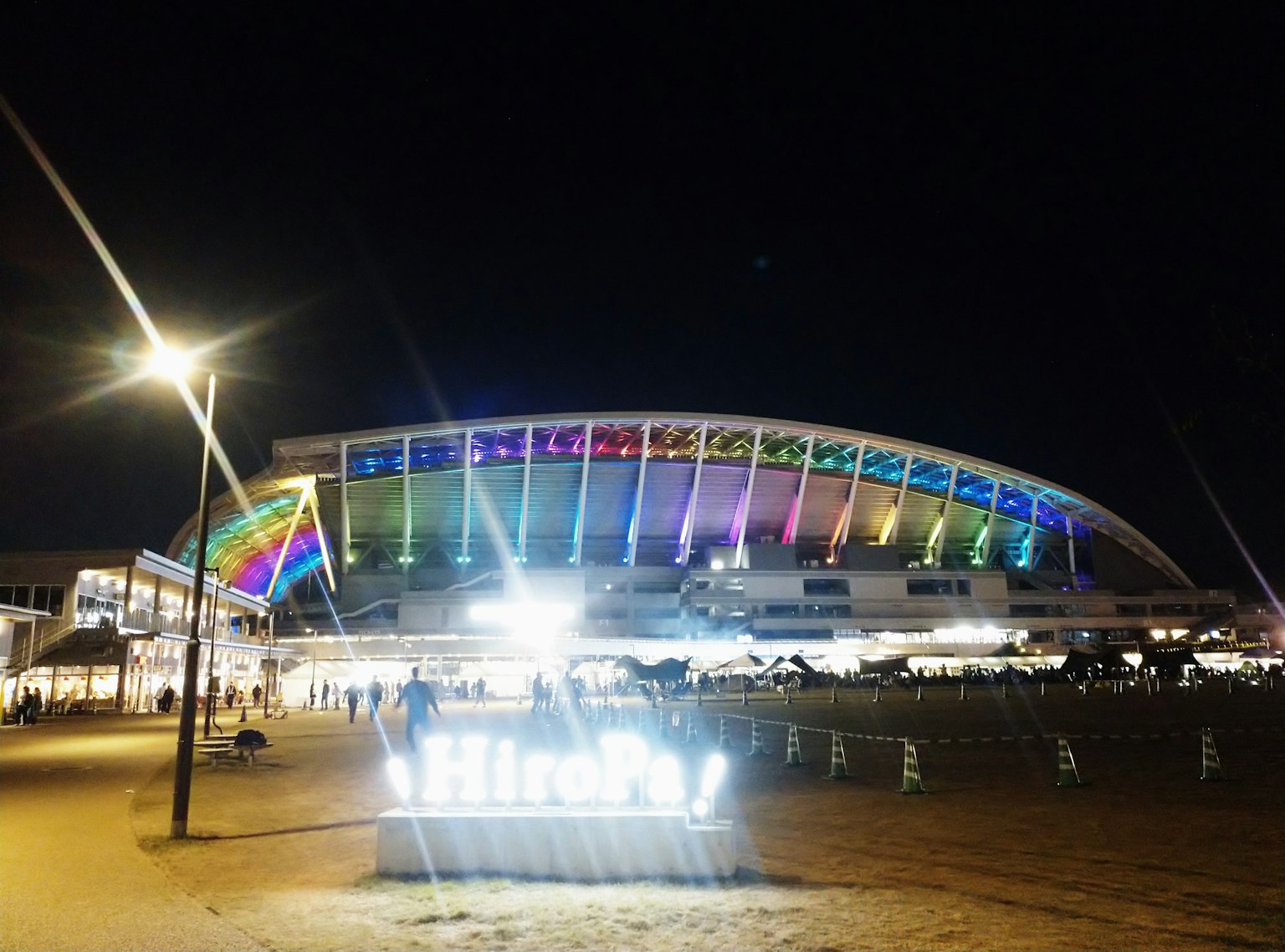 Stadion berwarna cerah di malam hari dengan lampu yang hidup