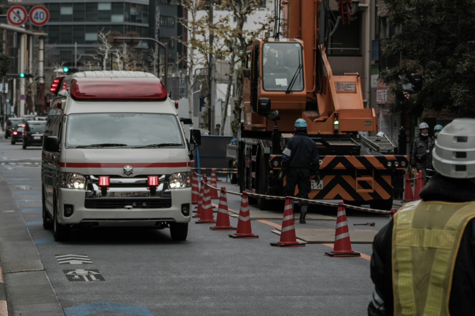 Cảnh thành phố với công trường xây dựng và xe cứu thương