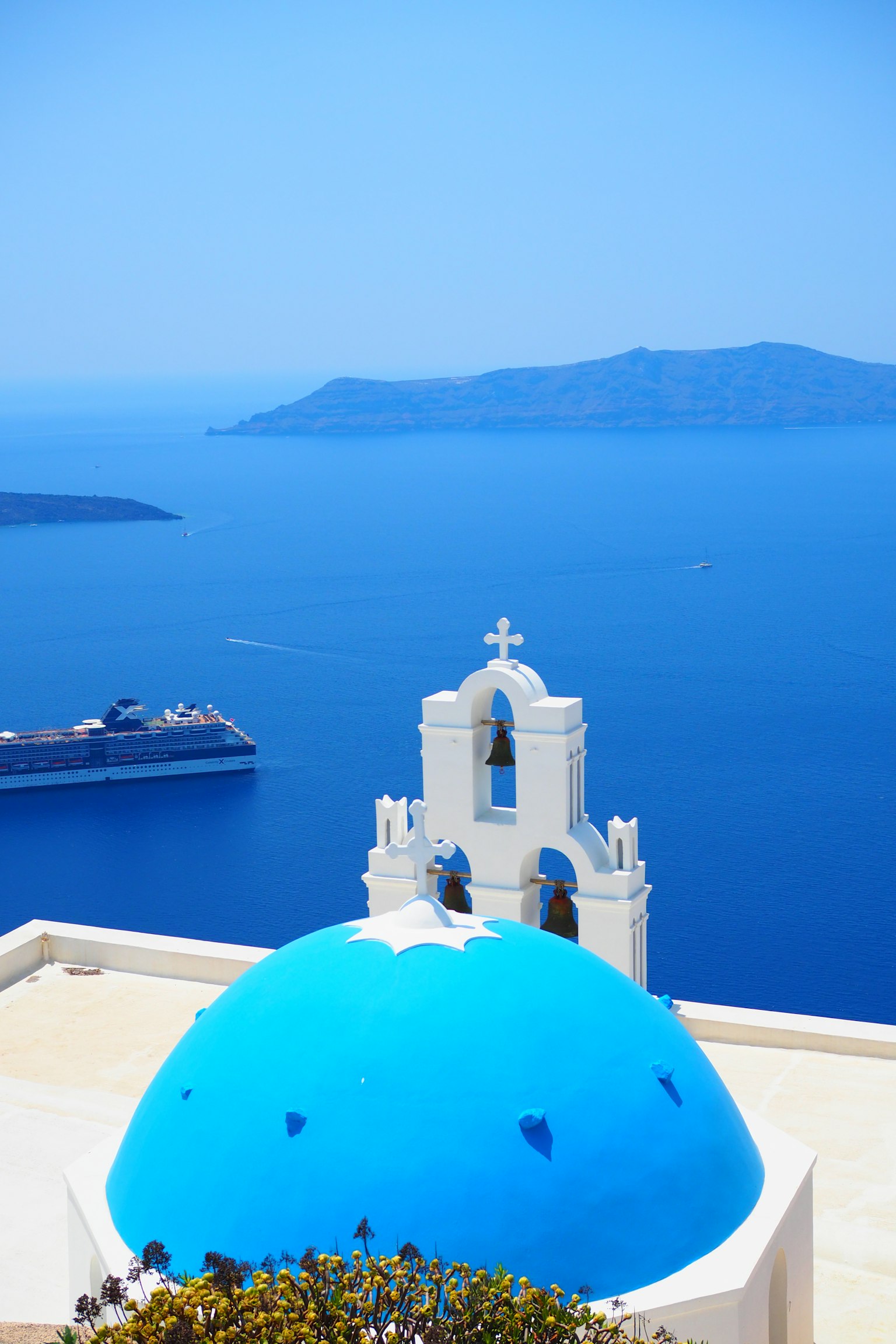 Cảnh quan của mái vòm xanh và tháp chuông trắng trên Biển Aegean