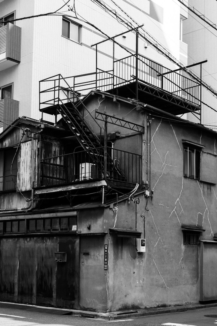 狭窄小巷里带楼梯与金属消防逃生梯的建筑外立面