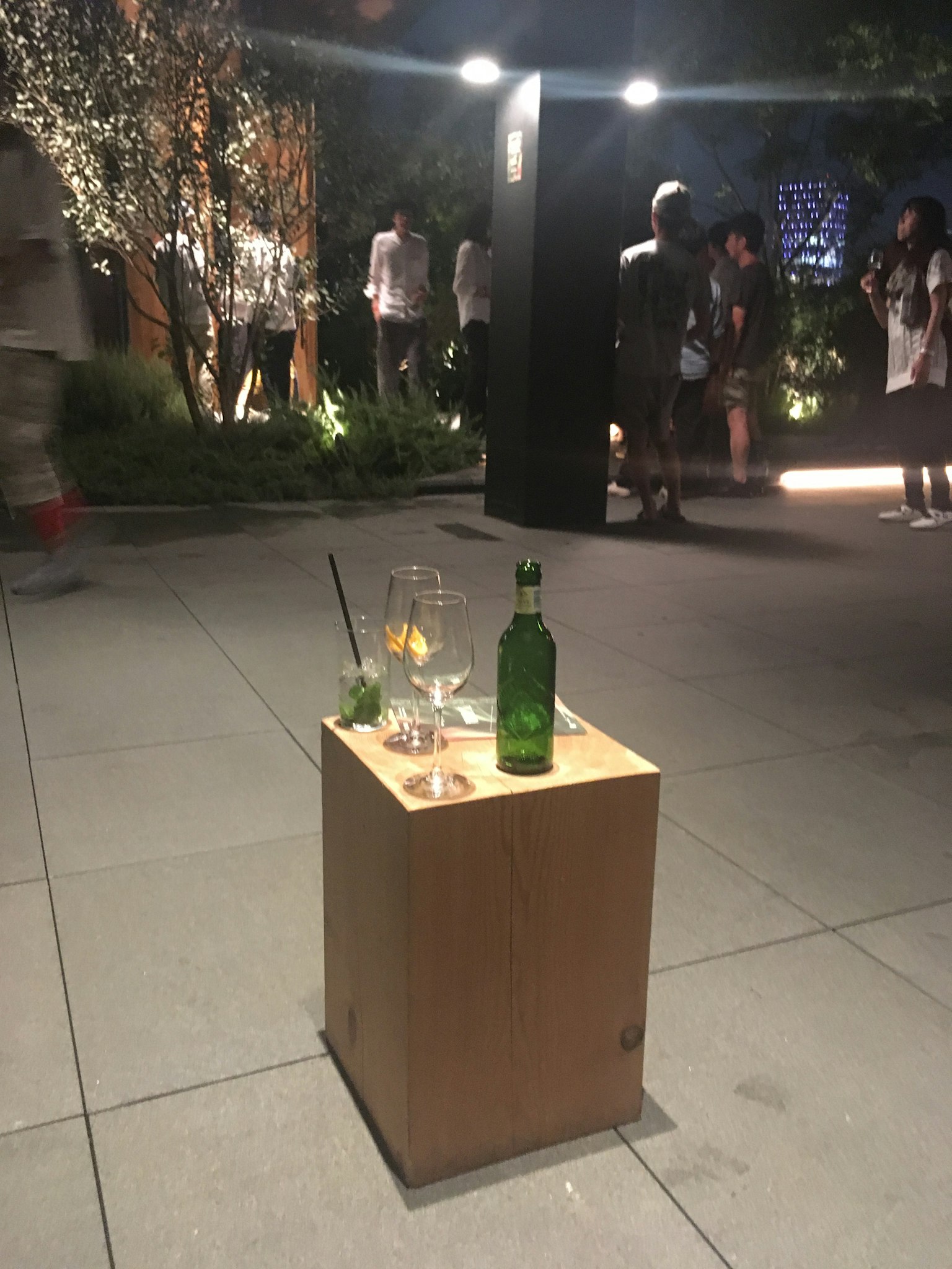 나무 받침대 위에 놓인 유리와 초록색 병 야외 밤 이벤트에서