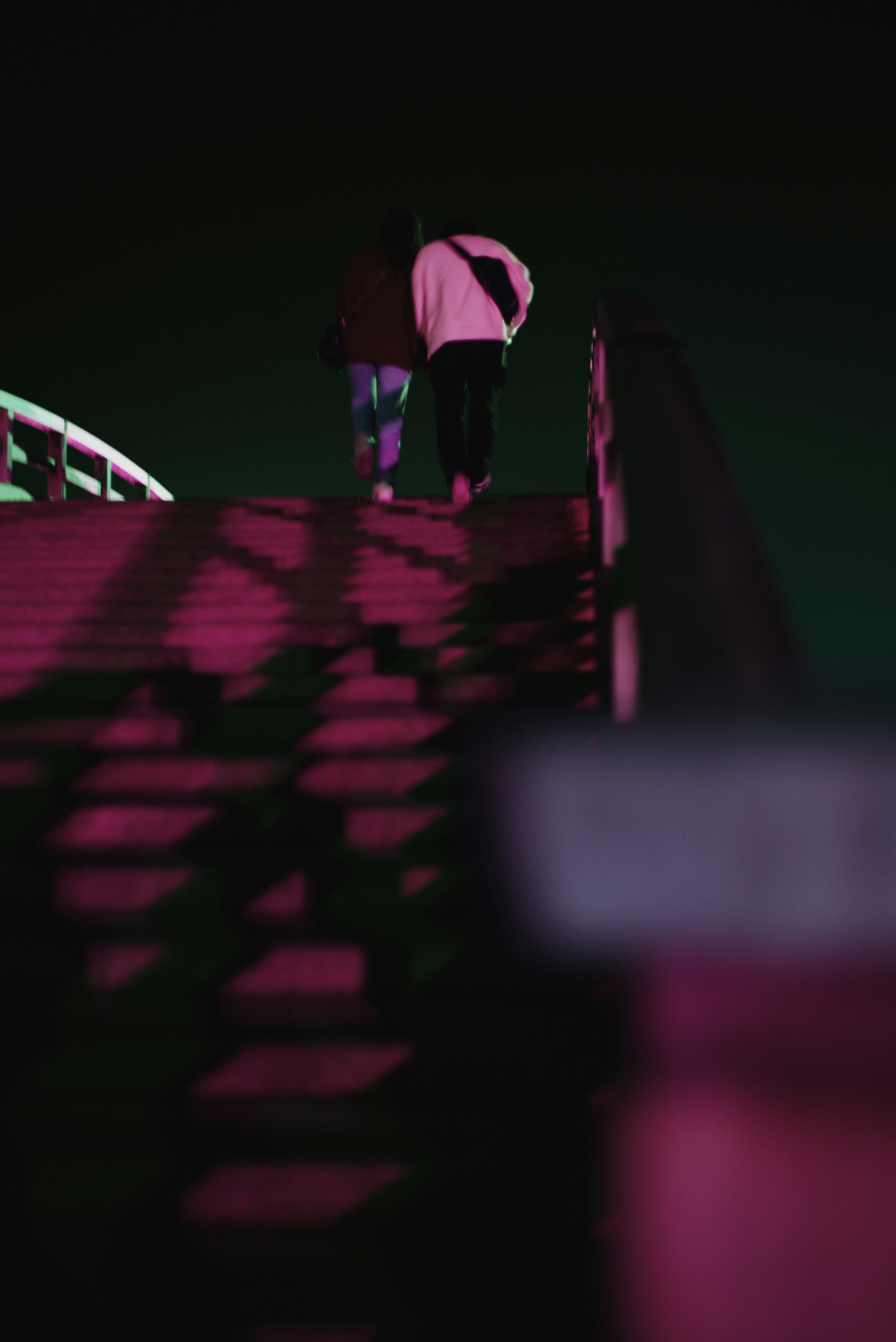 夜色中在亮燈的錦帶橋石階步道上行走的剪影