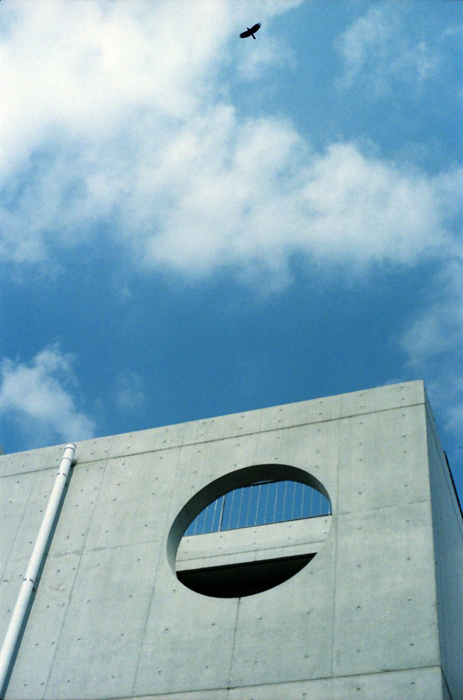 Concrete building with a circular window under a blue sky