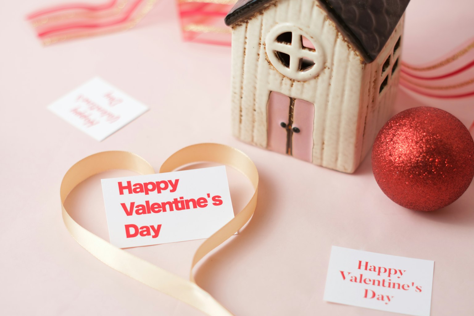 Hati dekoratif dengan kartu Selamat Hari Valentine dan rumah kayu kecil