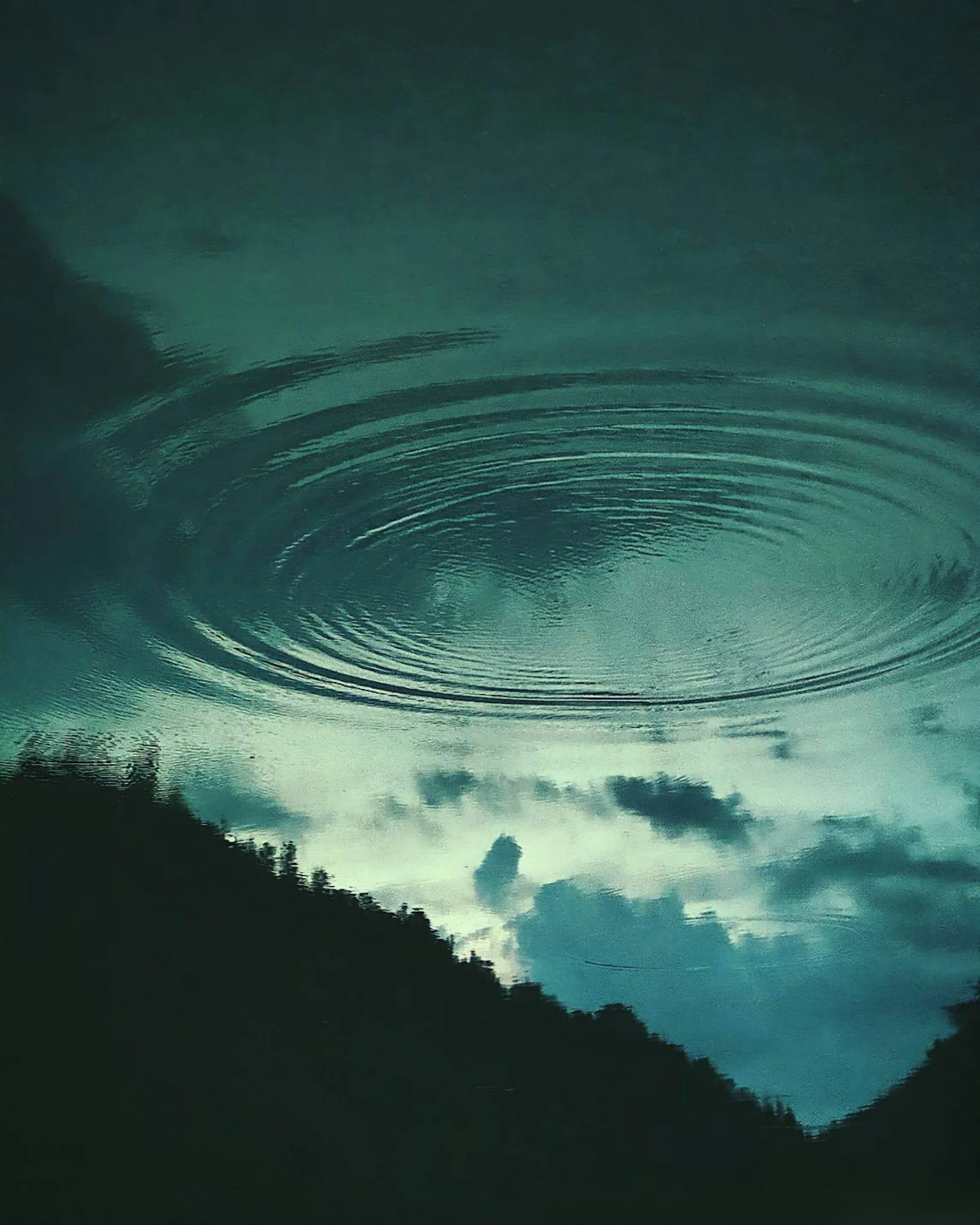 Ruhige Landschaft mit Wellen auf dem Wasser und dunklen Silhouetten von Bergen