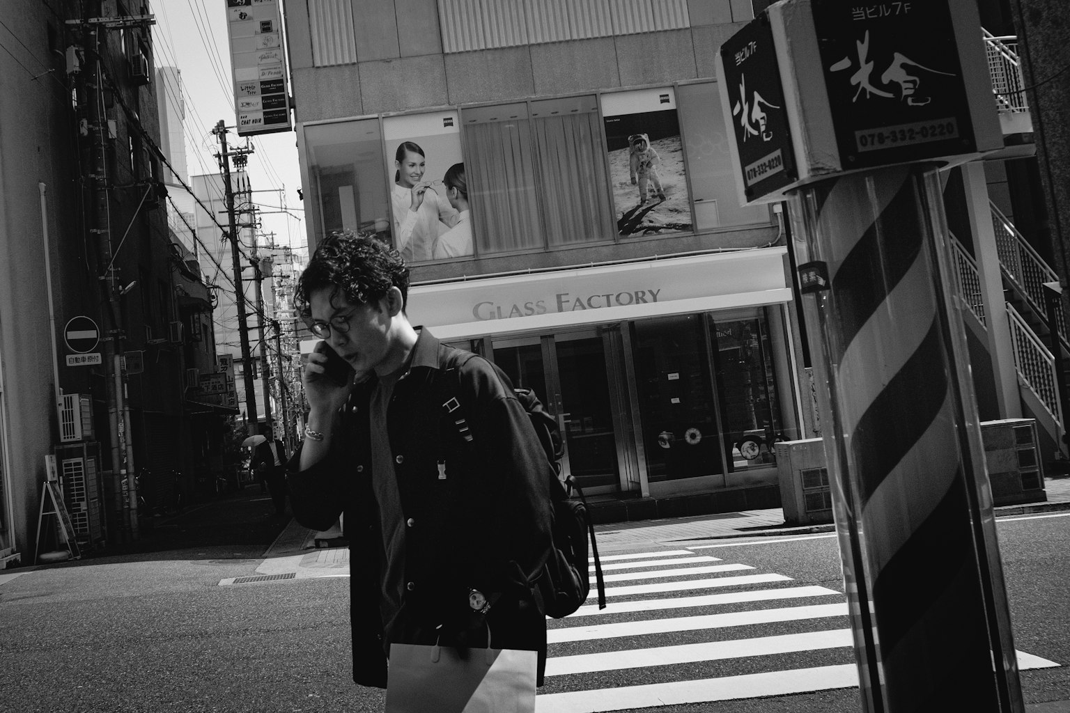 คนหนุ่มสาวเดินในทิวทัศน์เมืองขาวดำถือโทรศัพท์มือถือ