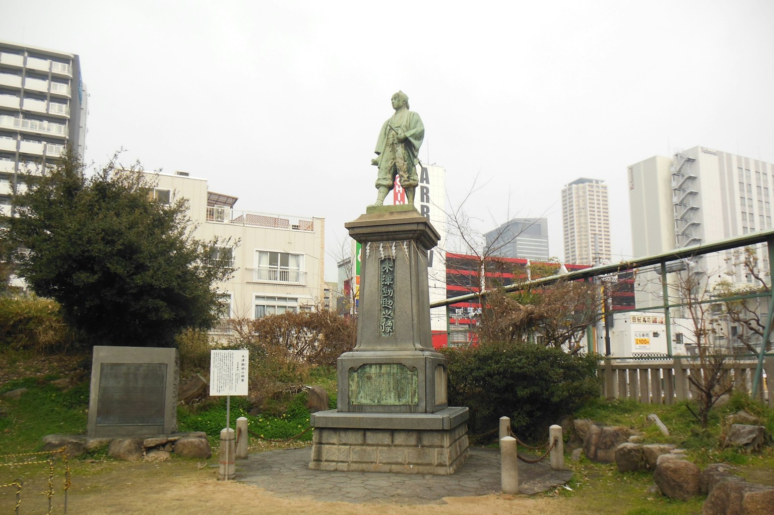 Statue dans un parc avec un paysage urbain en arrière-plan