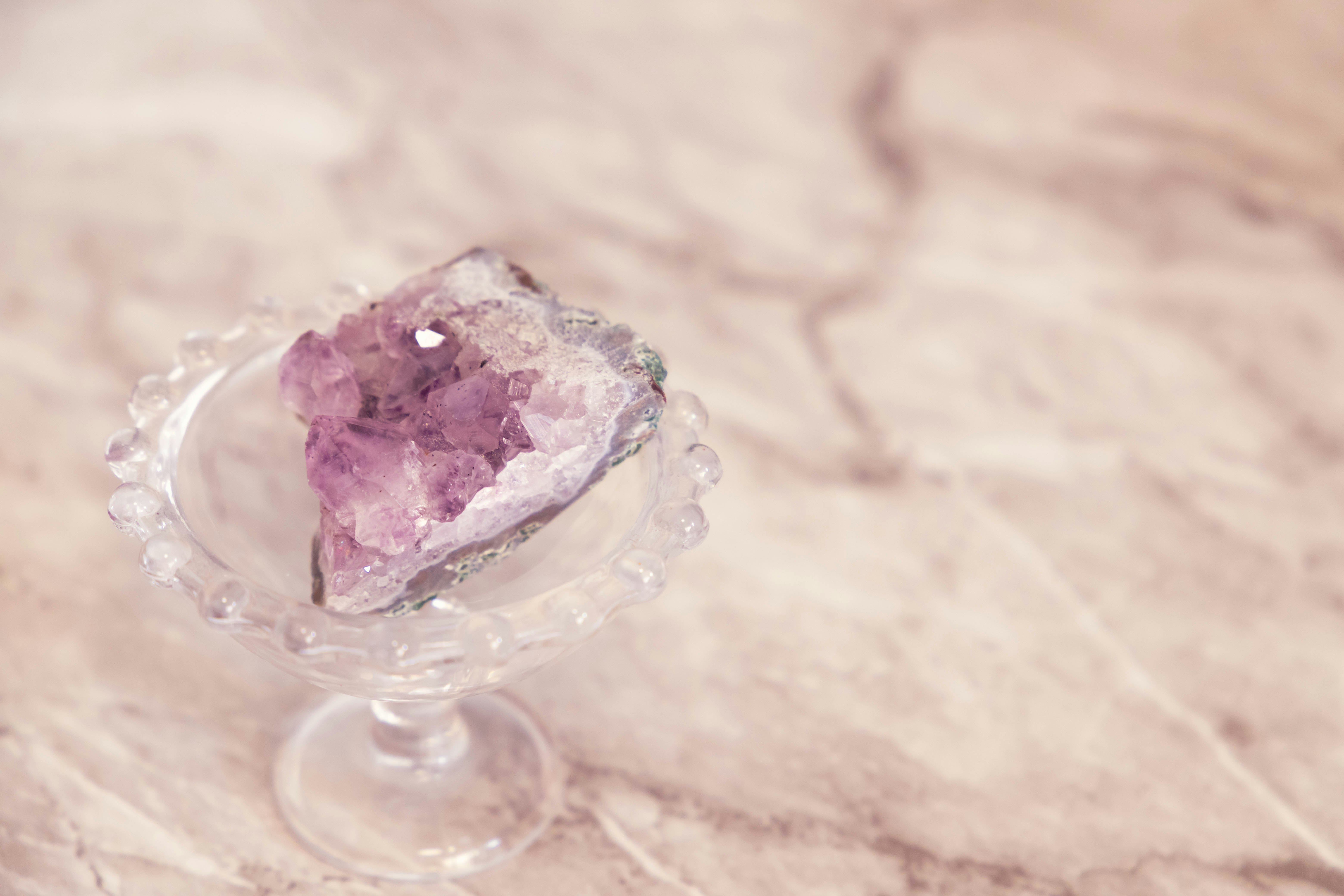bodegón con un platito de vidrio y una piedra de cristal rosa