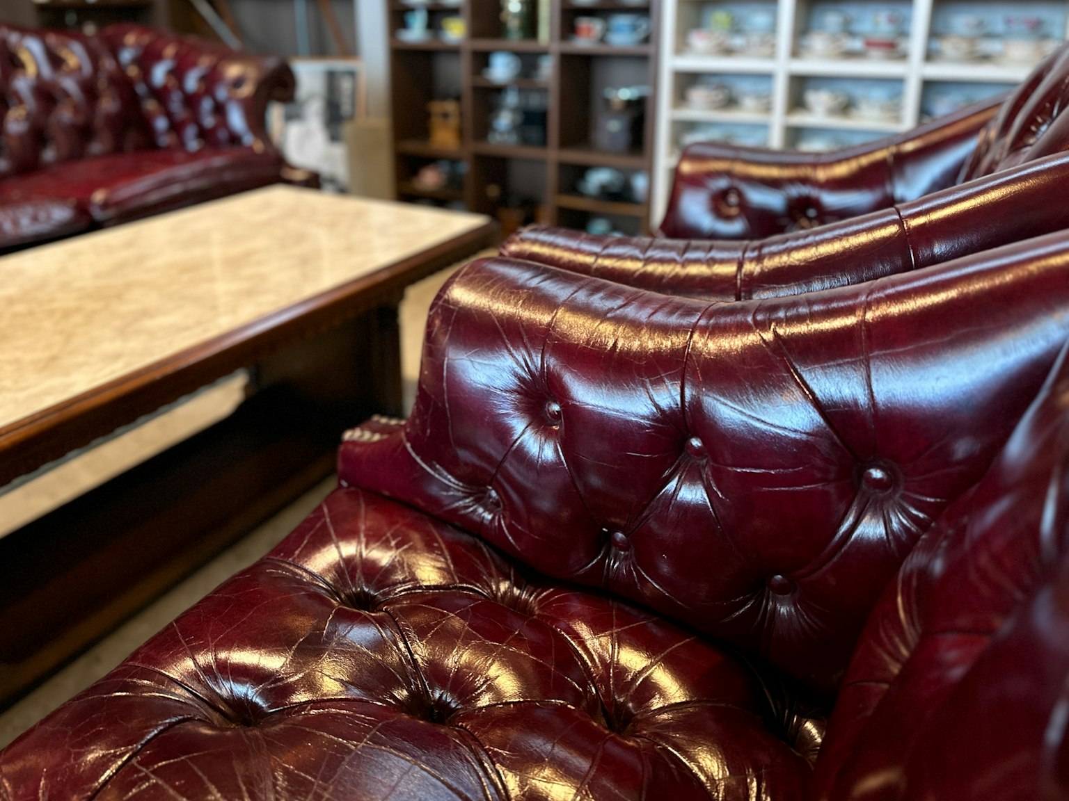 深红色皮革沙发的特写展示,带有纽扣设计