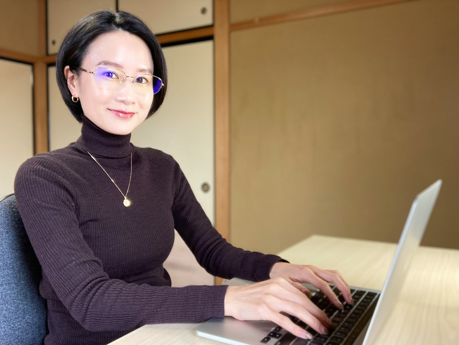 Một người phụ nữ làm việc trên máy tính xách tay trong không gian trong nhà ấm cúng