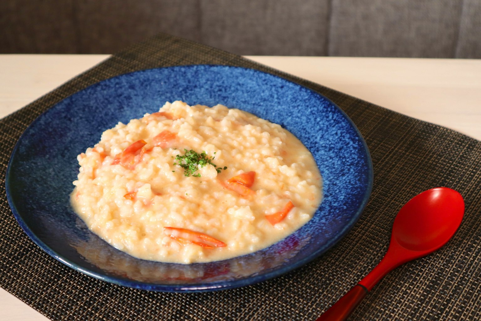 Risotto crémeux aux crevettes servi dans une assiette bleue