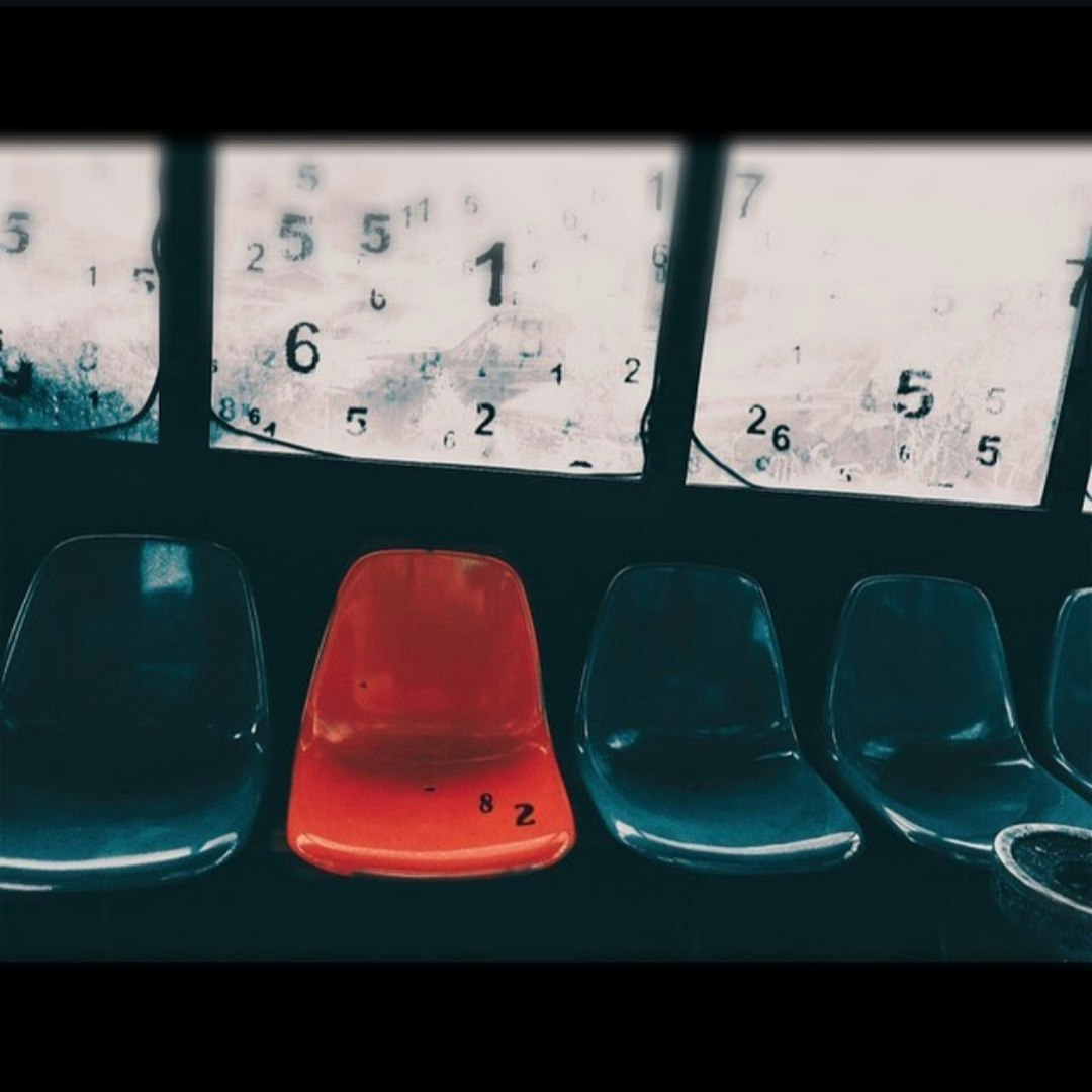 バス停のベンチに並ぶ赤と青の椅子と車内の数字表示