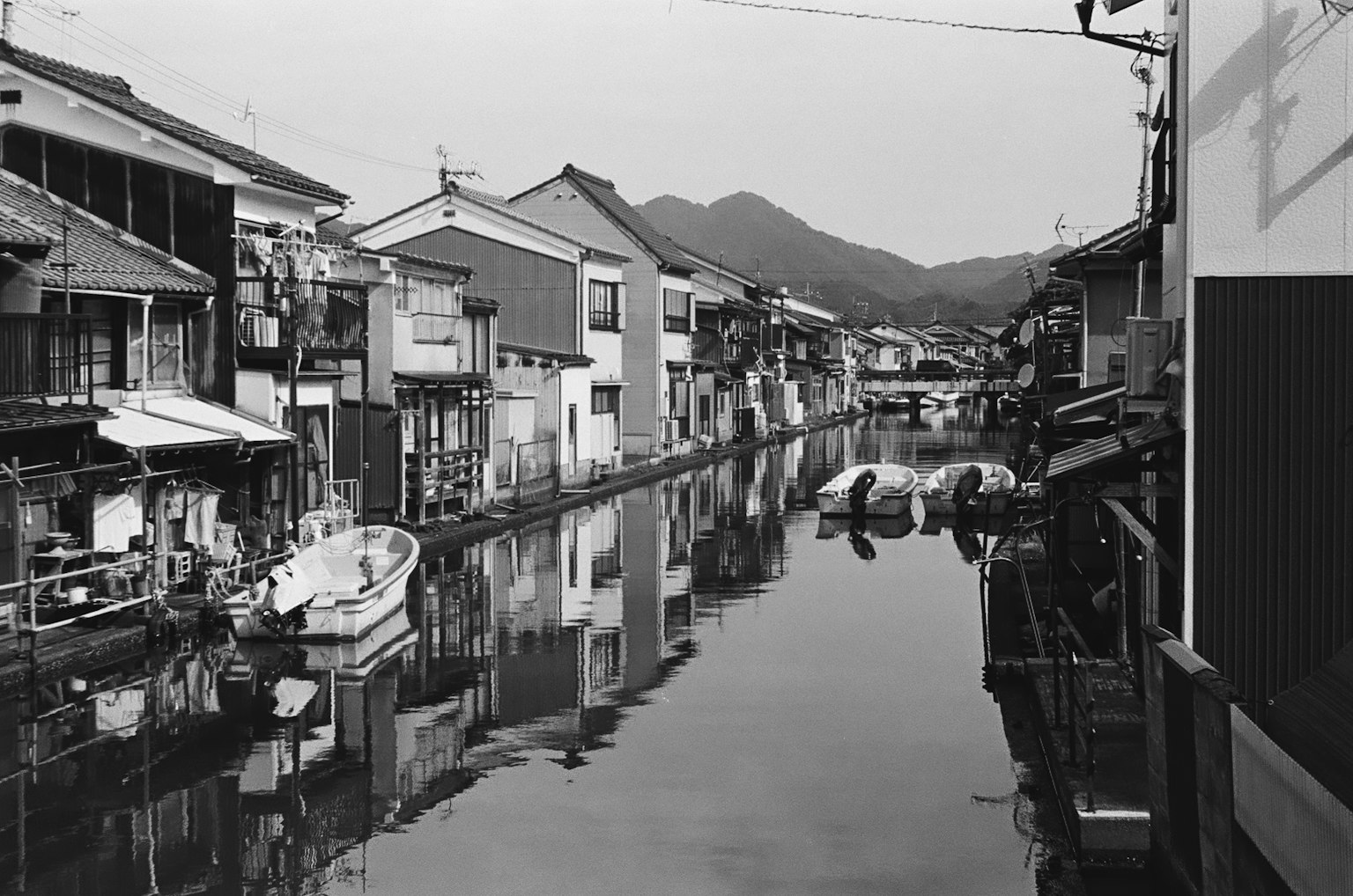 Cảnh nhà cũ bên dòng kênh yên tĩnh Ảnh đen trắng với núi ở phía sau