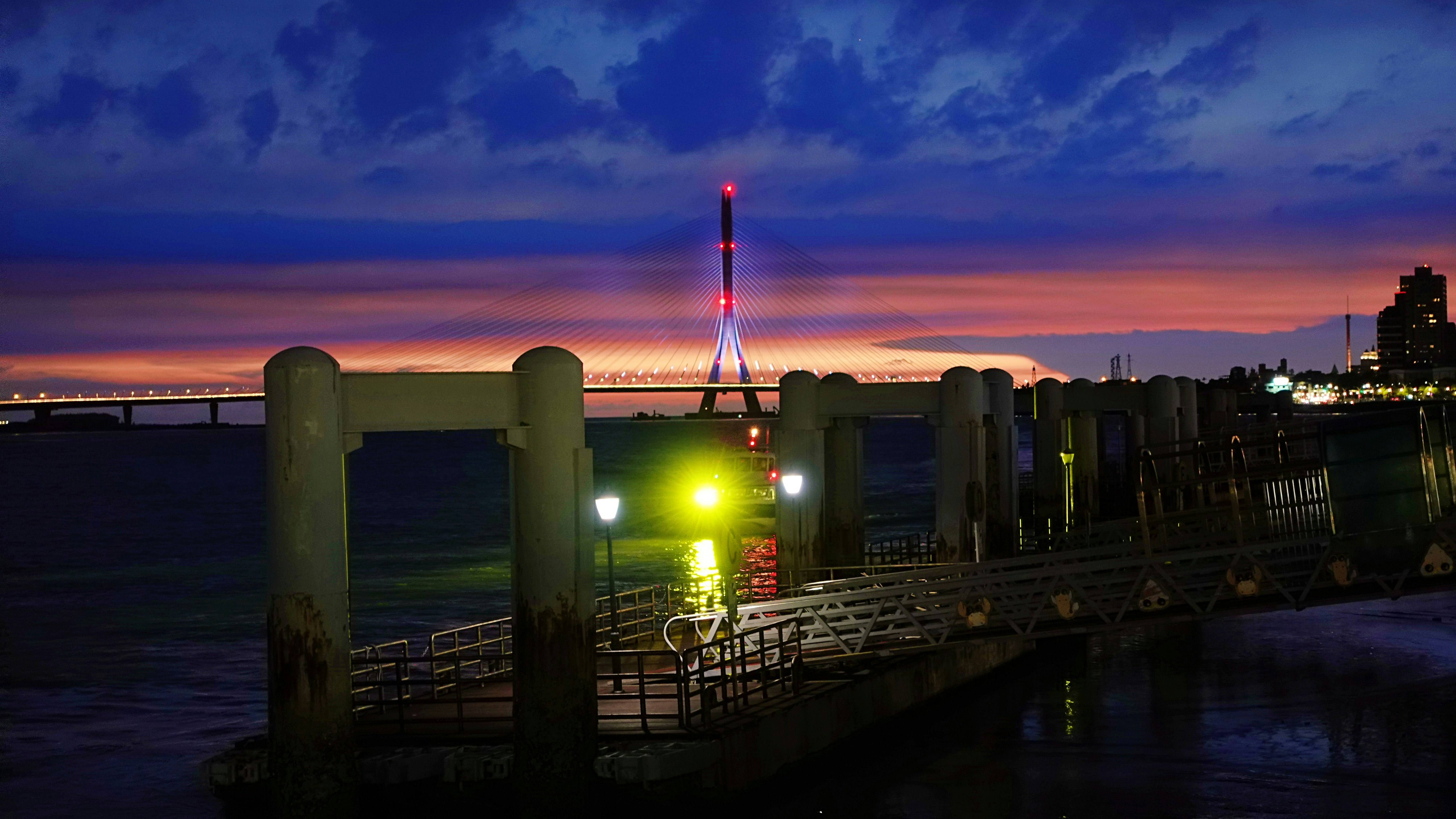 夕暮れの海辺の桟橋と沖合の夜景、淡水