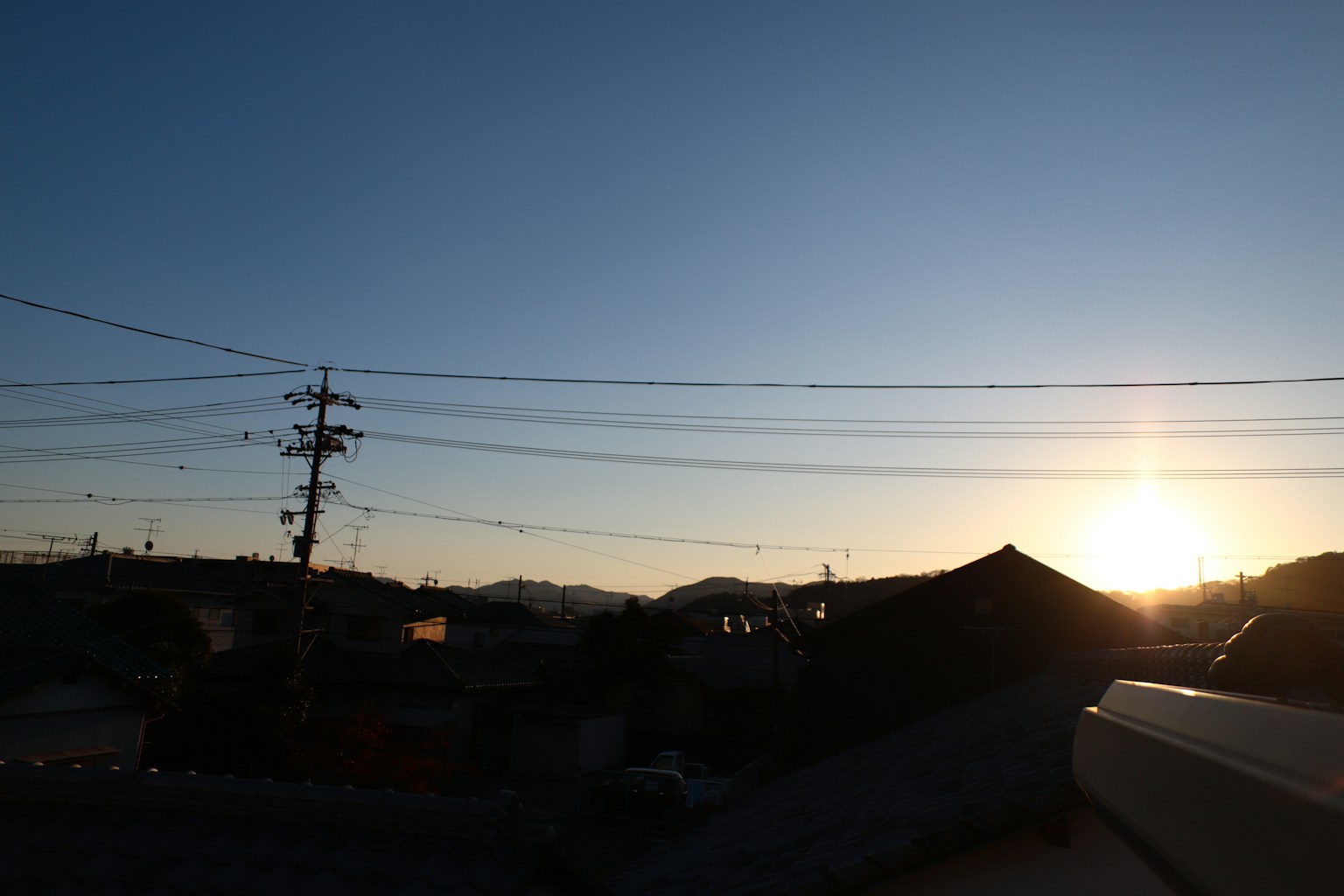 Vista del tramonto su un'area residenziale giapponese con linee elettriche