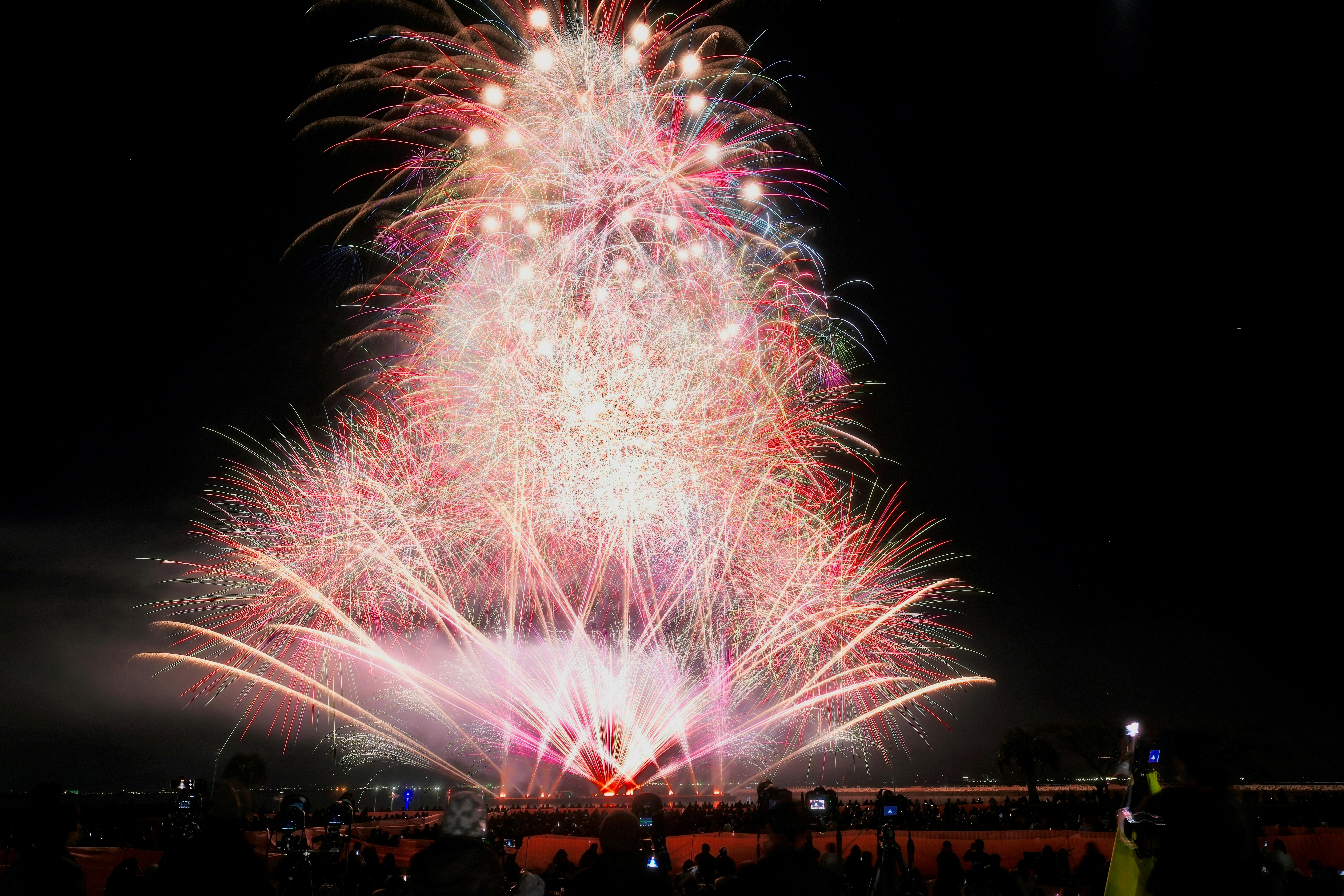 Feuerwerk am Nachthimmel mit Silhouetten von Zuschauern (Gamagori, Laguna Beach)