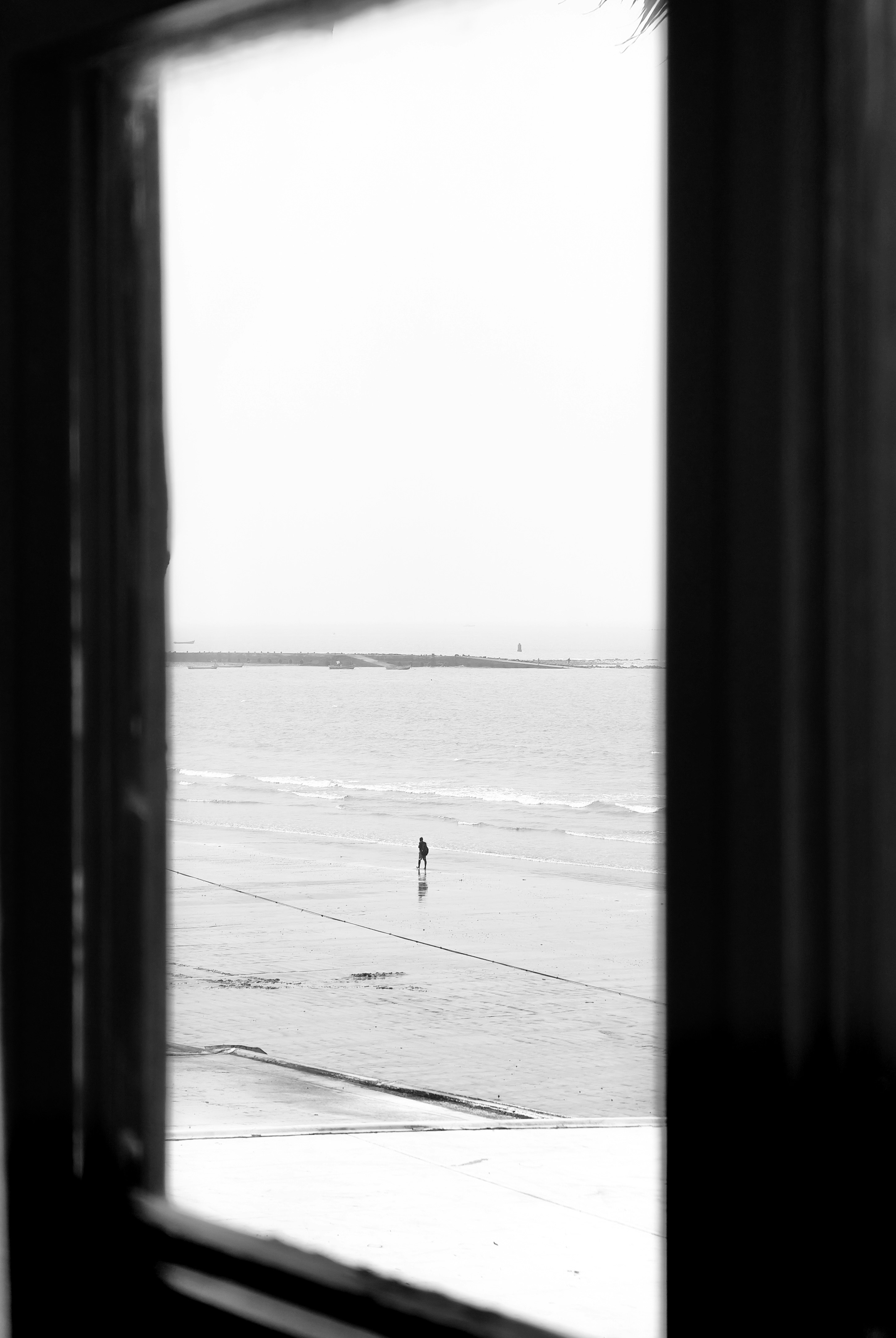 窓枠越しに見える海と一人の人物