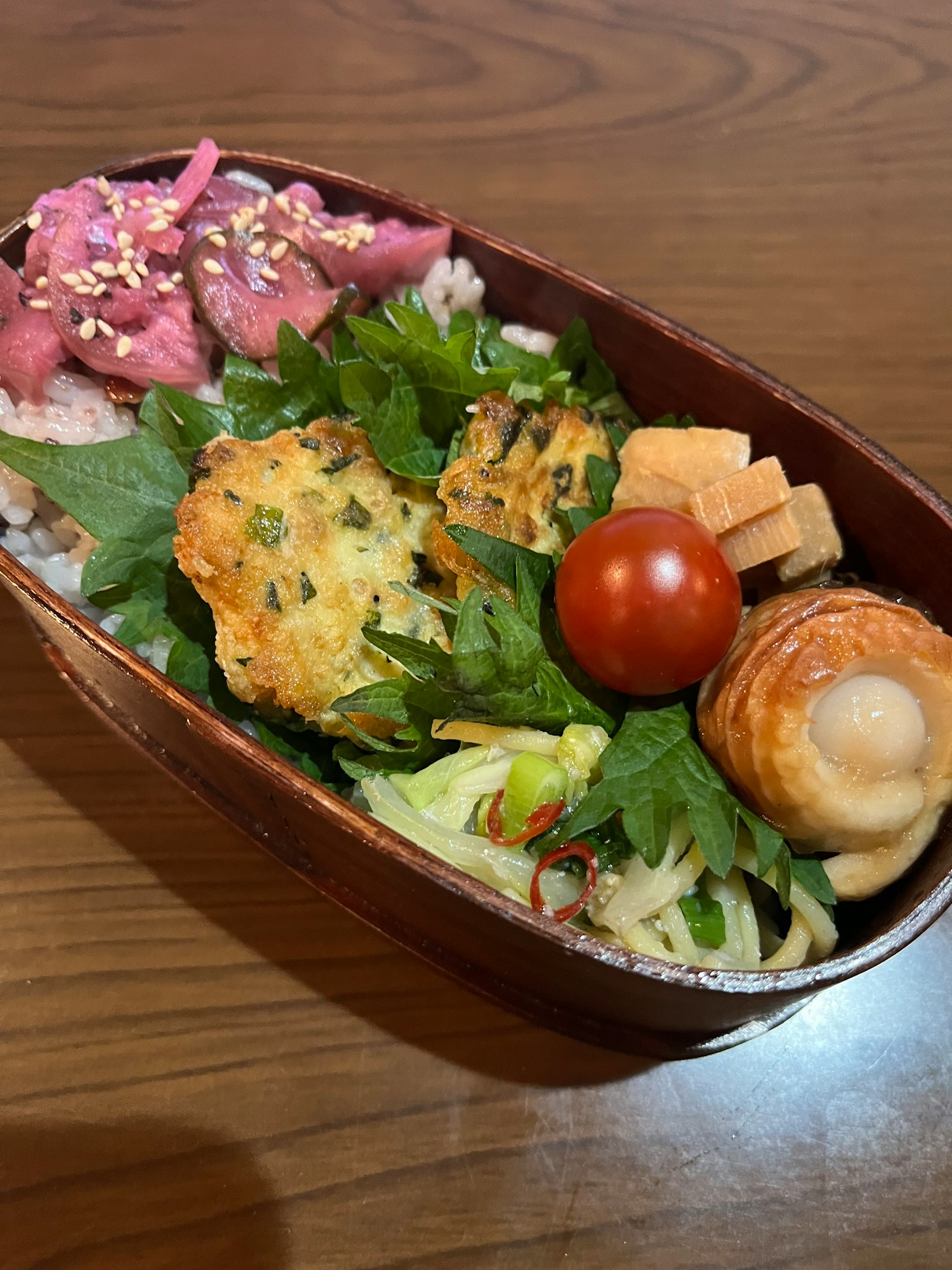 一個裝滿各種菜餚的便當盒，包括米飯、蔬菜和櫻桃番茄