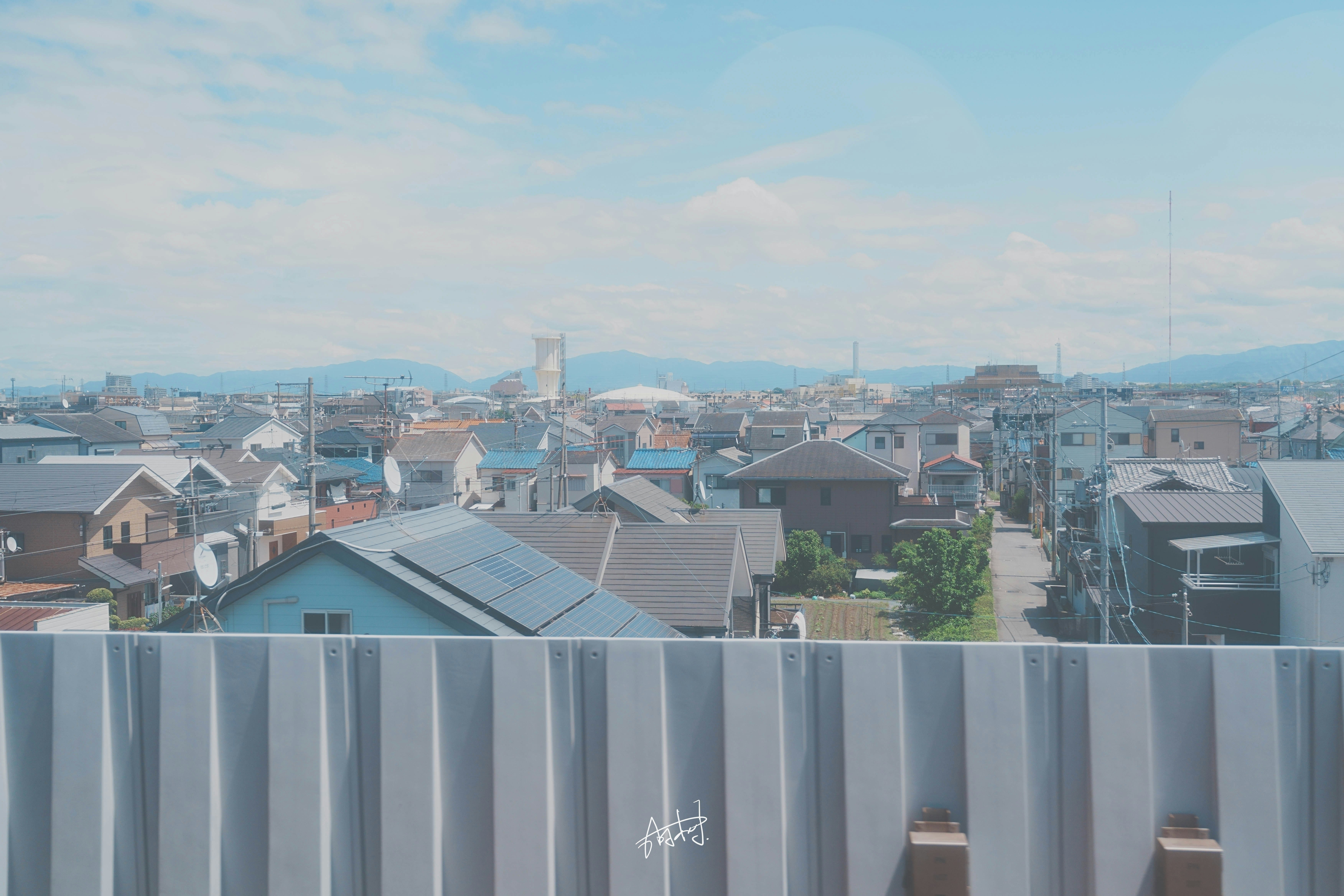 屋上から見下ろす住宅街と遠景の工場群