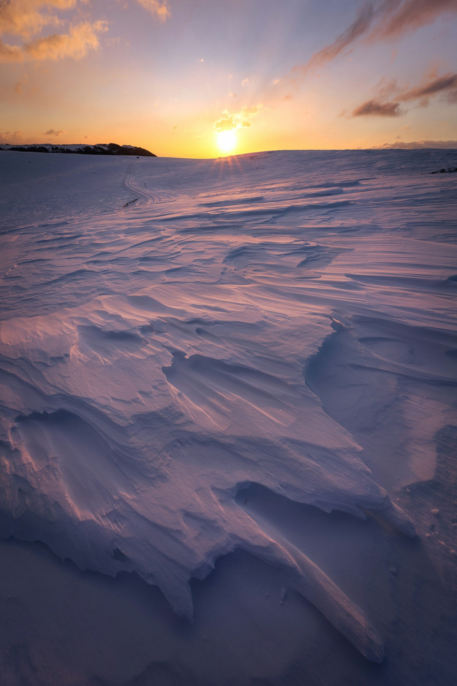 Beautiful landscape of snow-covered terrain with a glowing sunset