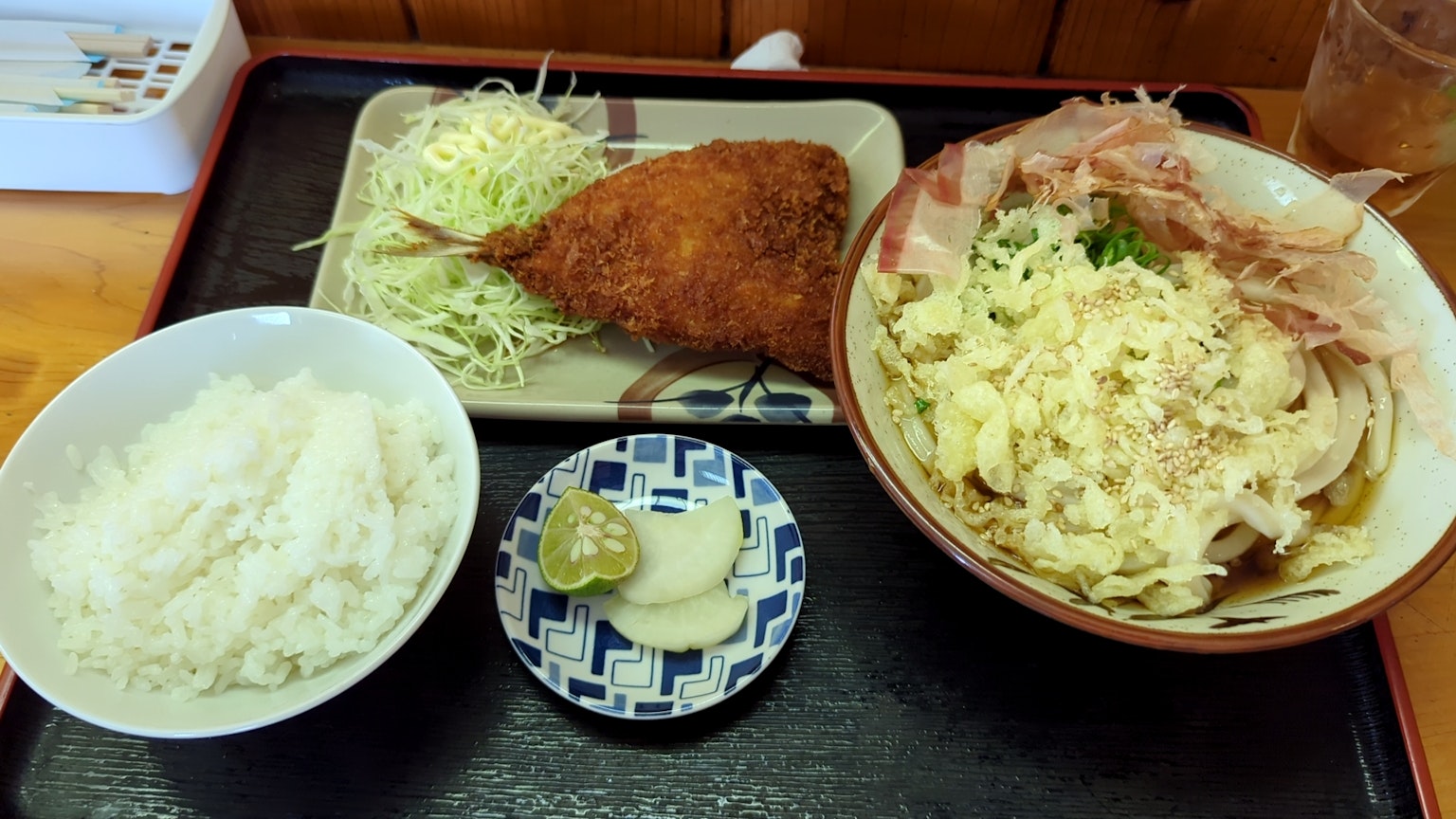 A Japanese meal featuring rice, cabbage, a croquette, and an egg bowl on a tray