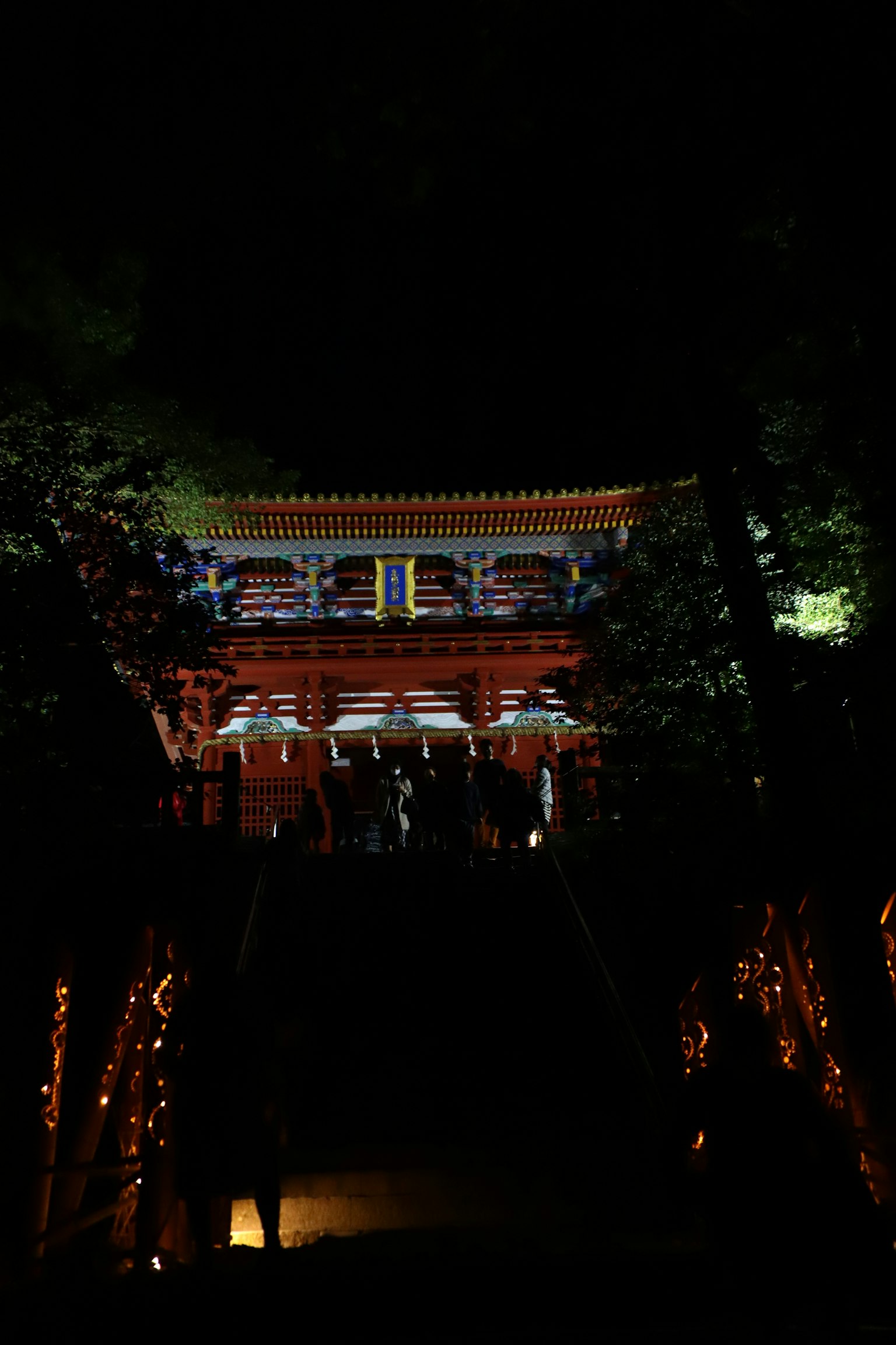Belle porte rouge d'un sanctuaire illuminée la nuit