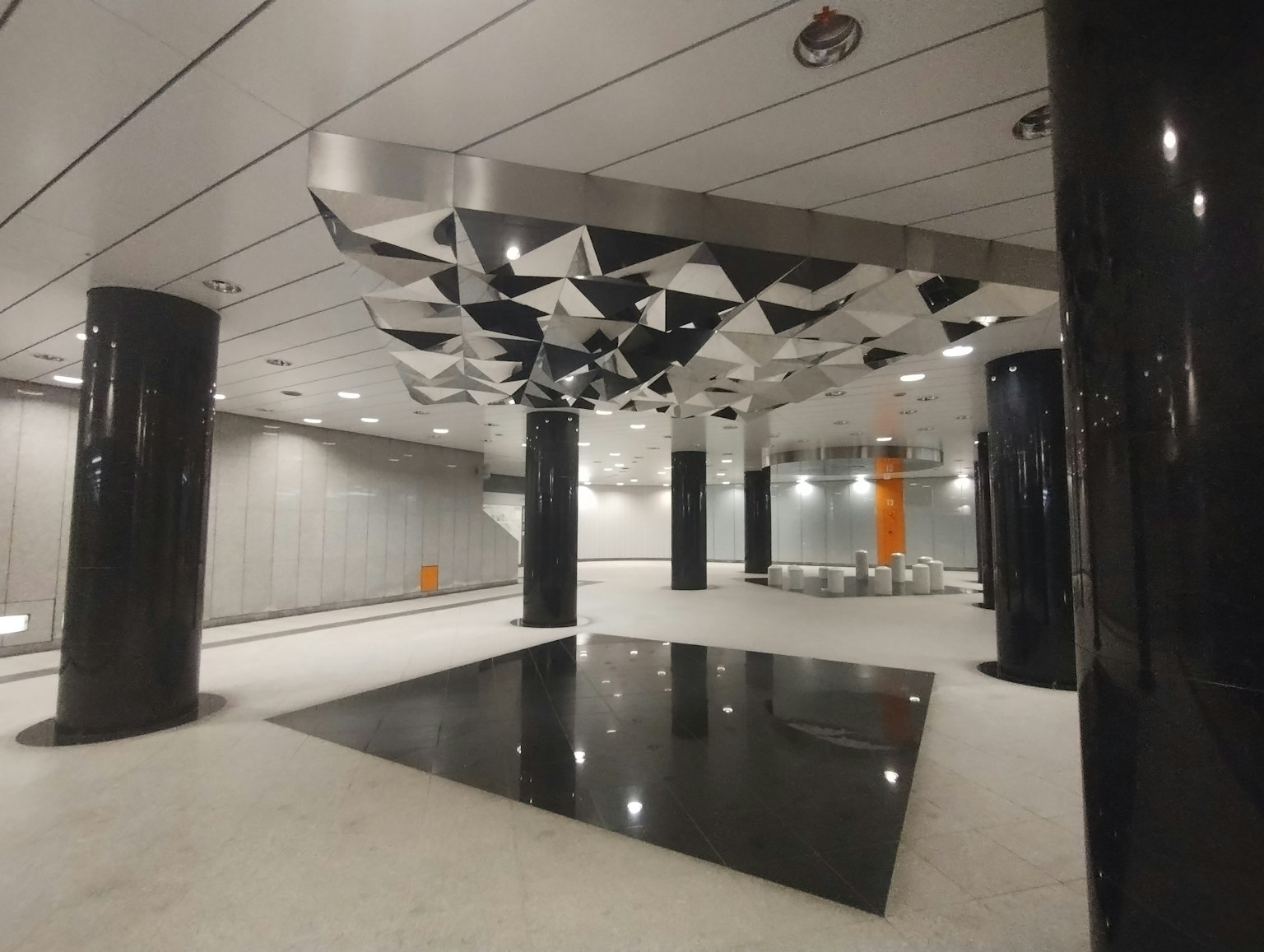 Modernes U-Bahn-Station-Interieur mit schwarzen Säulen und sternförmiger Decke schwarzem Boden