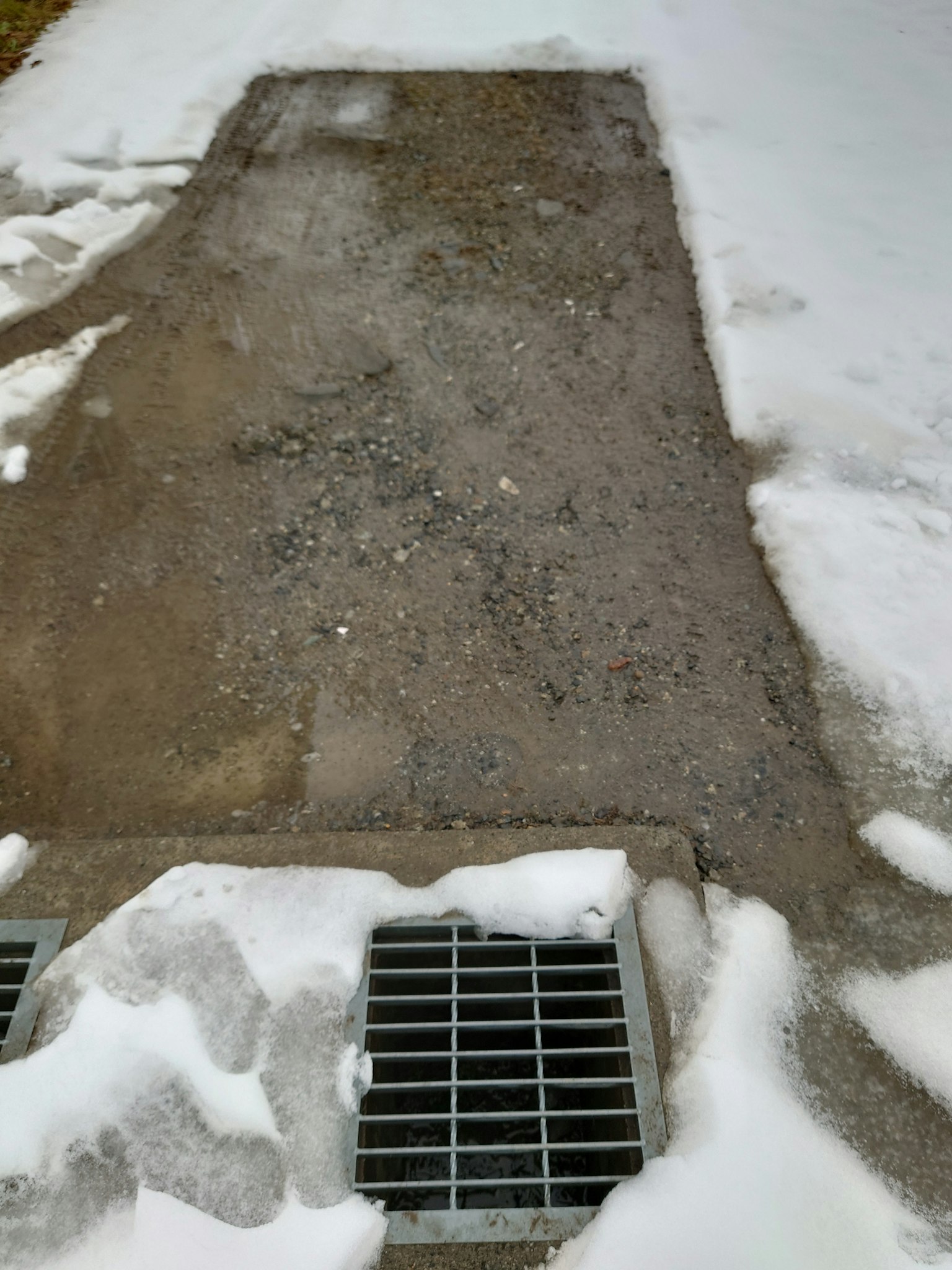 地面上有剩餘的雪和排水格柵