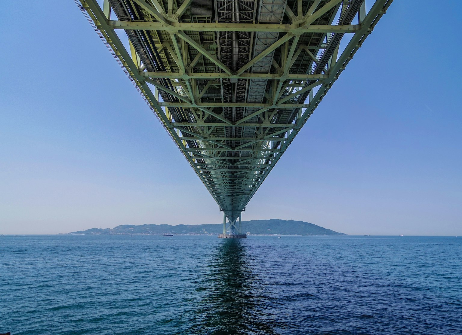 Pemandangan laut dan langit biru dari bawah jembatan