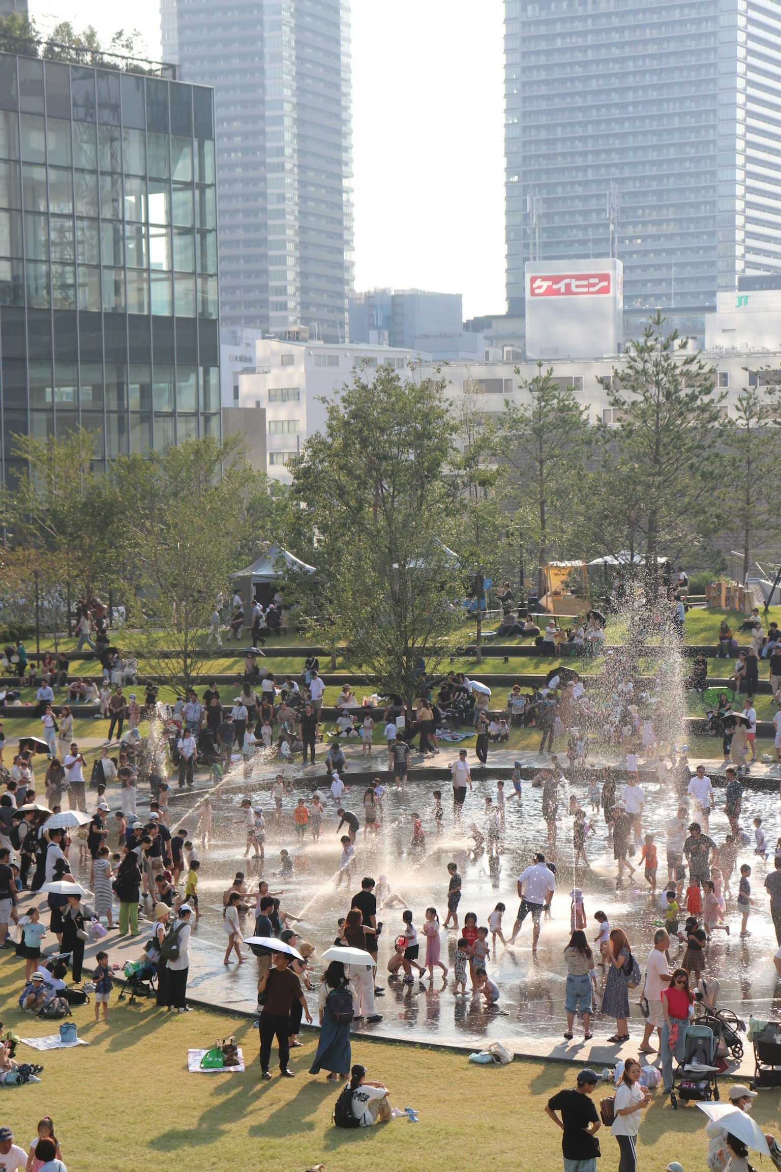 Urban park scene with people playing around a fountain